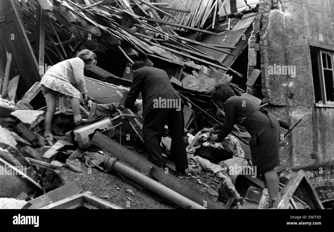 Superstiti del London blitz, 1940; la ricerca nei ruderi di case bombardate. Seconda guerra mondiale Foto Stock
