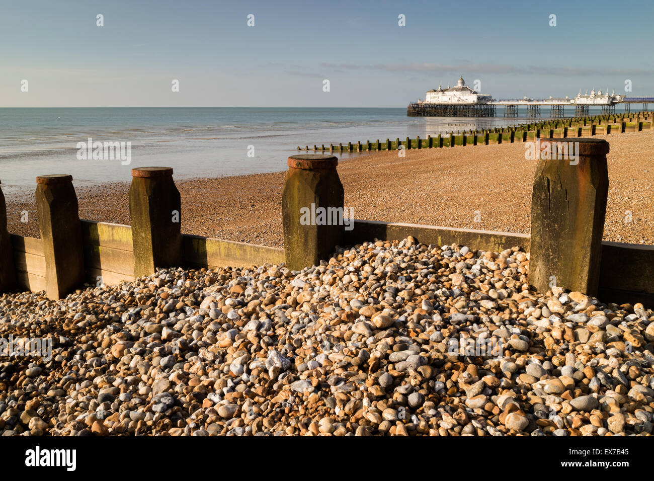 Pennelli e il molo su di una spiaggia di ciottoli di Eastbourne, East Sussex, Inghilterra Foto Stock