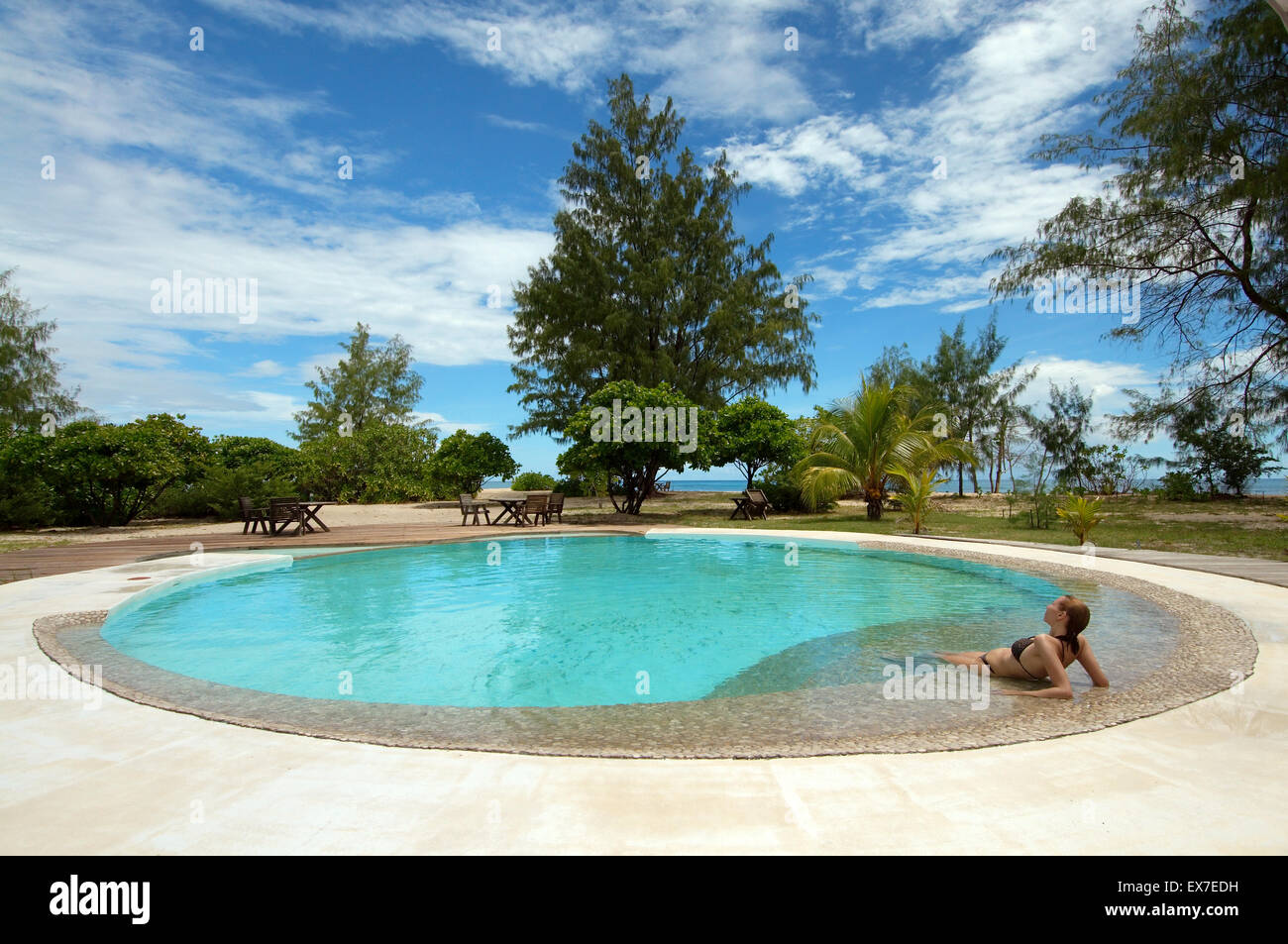 Giovane donna si trova in una piscina circolare, Denis Island, Seicelle Foto Stock