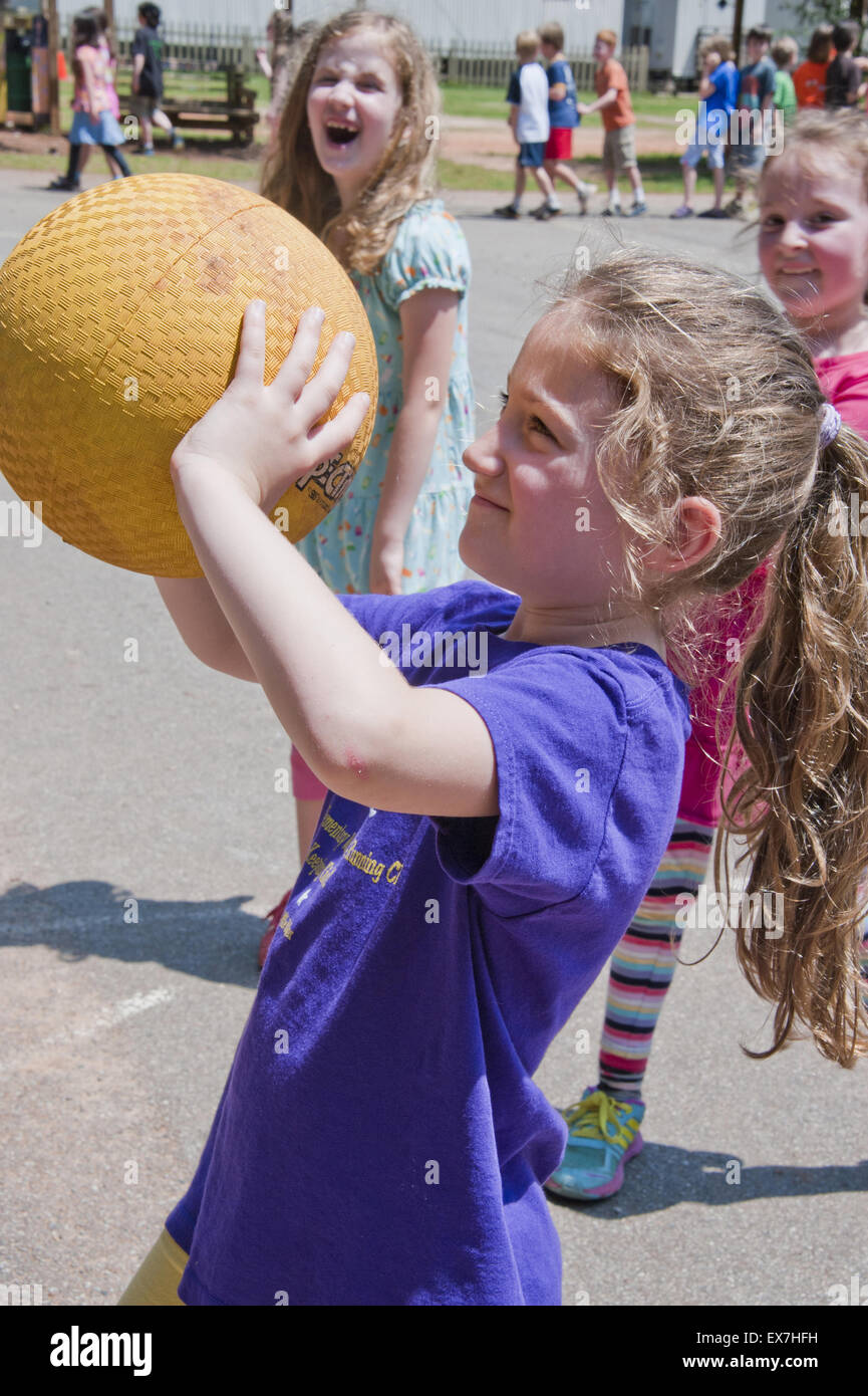 Bambino giocare a basket durante un esterno di educazione fisica classe. Foto Stock