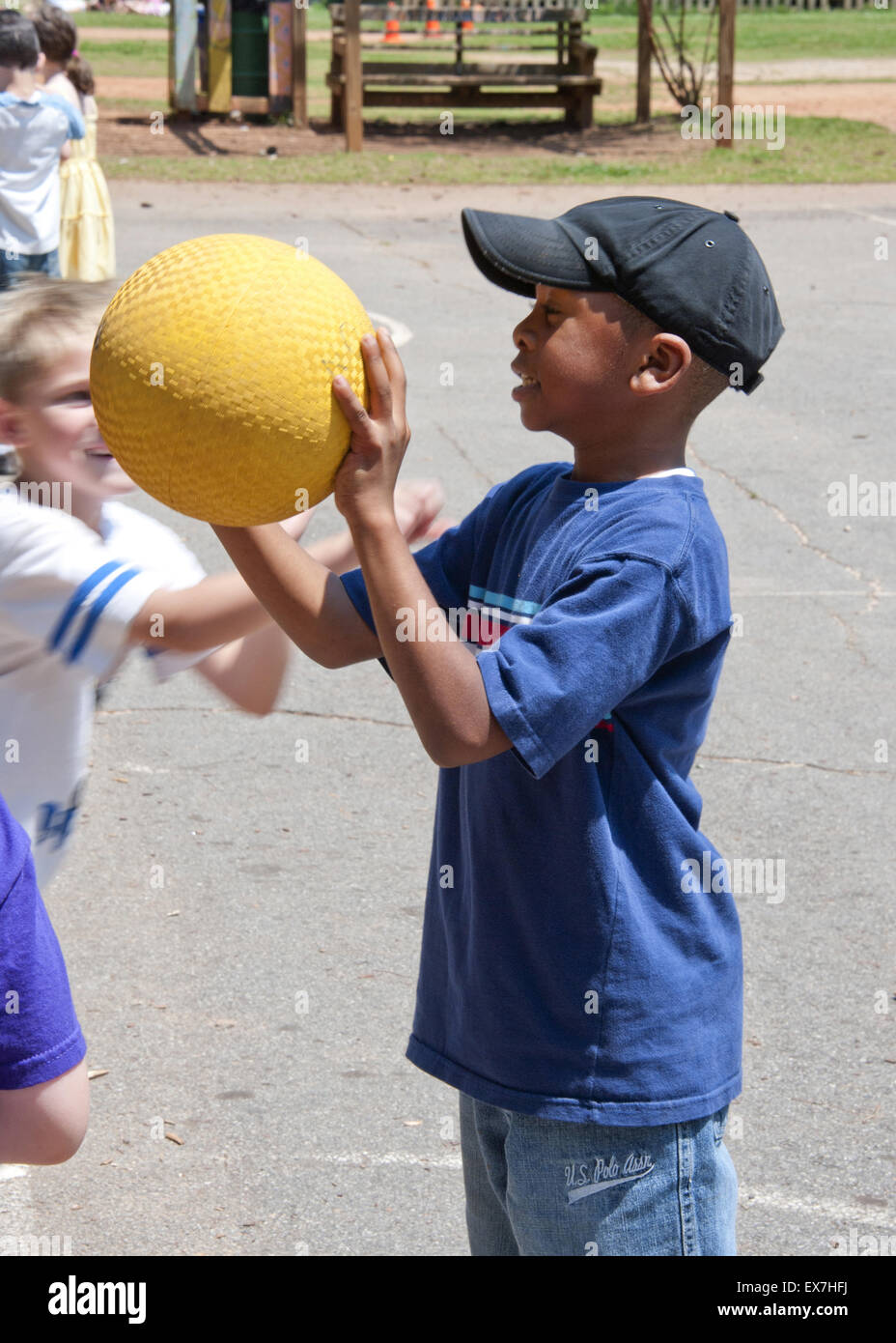 Bambino giocare a basket durante un esterno di educazione fisica classe. Foto Stock