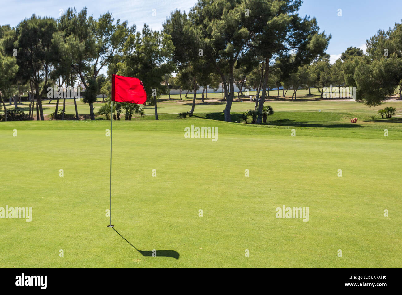 Bandiera rossa nel foro su un verde campo da golf Foto Stock
