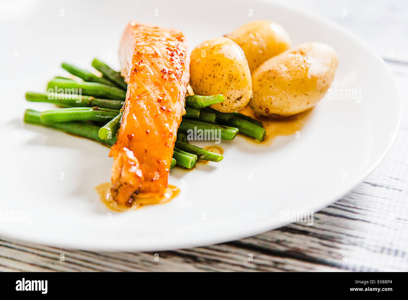 La soia, il peperoncino e lo sciroppo d'acero salsa con salmone baby le patate e i fagiolini verdi Foto Stock