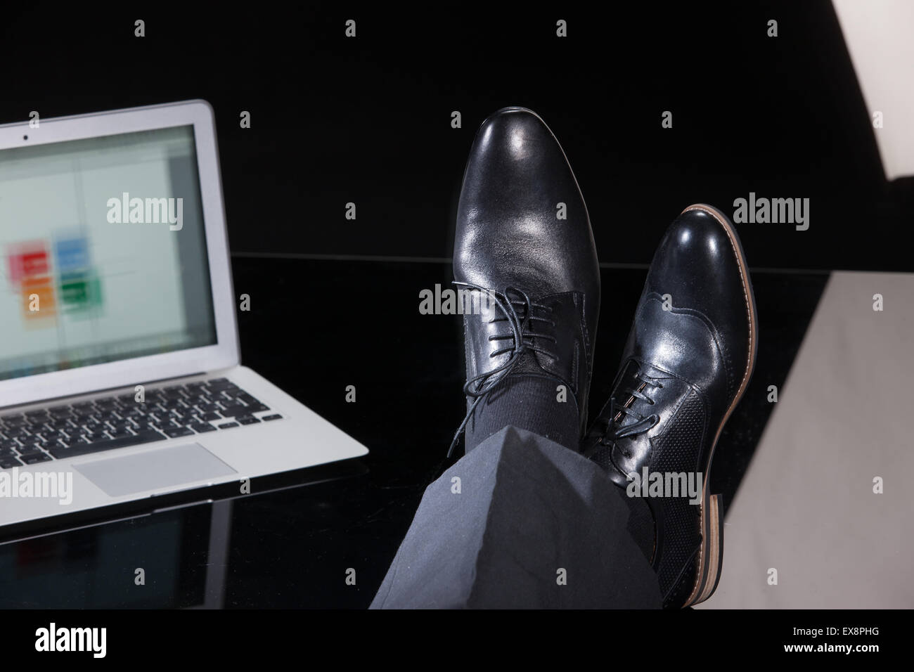 Uomo uomini persone gamba maschio Pantaloni Pantaloni scarpe computer notebook schermo tastiera di monitorare le informazioni di tabella di riflessione di vetro technol Foto Stock