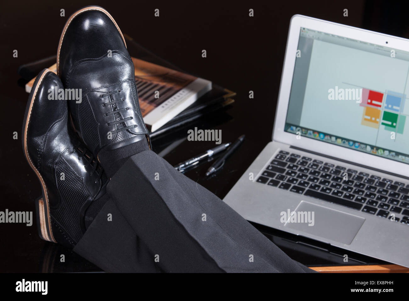 Uomo uomini persone gamba maschio Pantaloni Pantaloni scarpe computer notebook schermo tastiera di monitorare le informazioni di tabella di riflessione di vetro technol Foto Stock