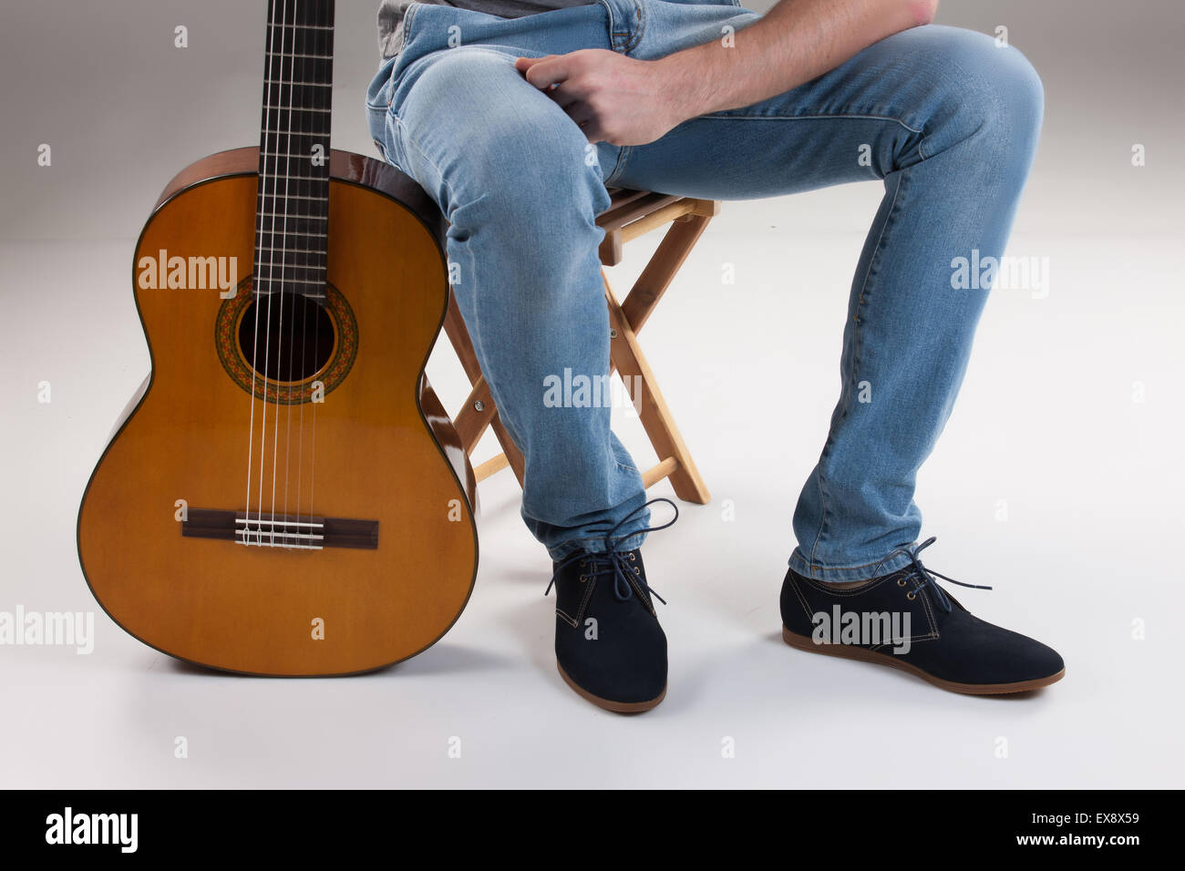 Uomo uomini studio maschio jeans denim di sfondo dell'oggetto suonare la chitarra parte del corpo dello strumento musicale gruppo isolato di stringa scarpe arte collo Foto Stock