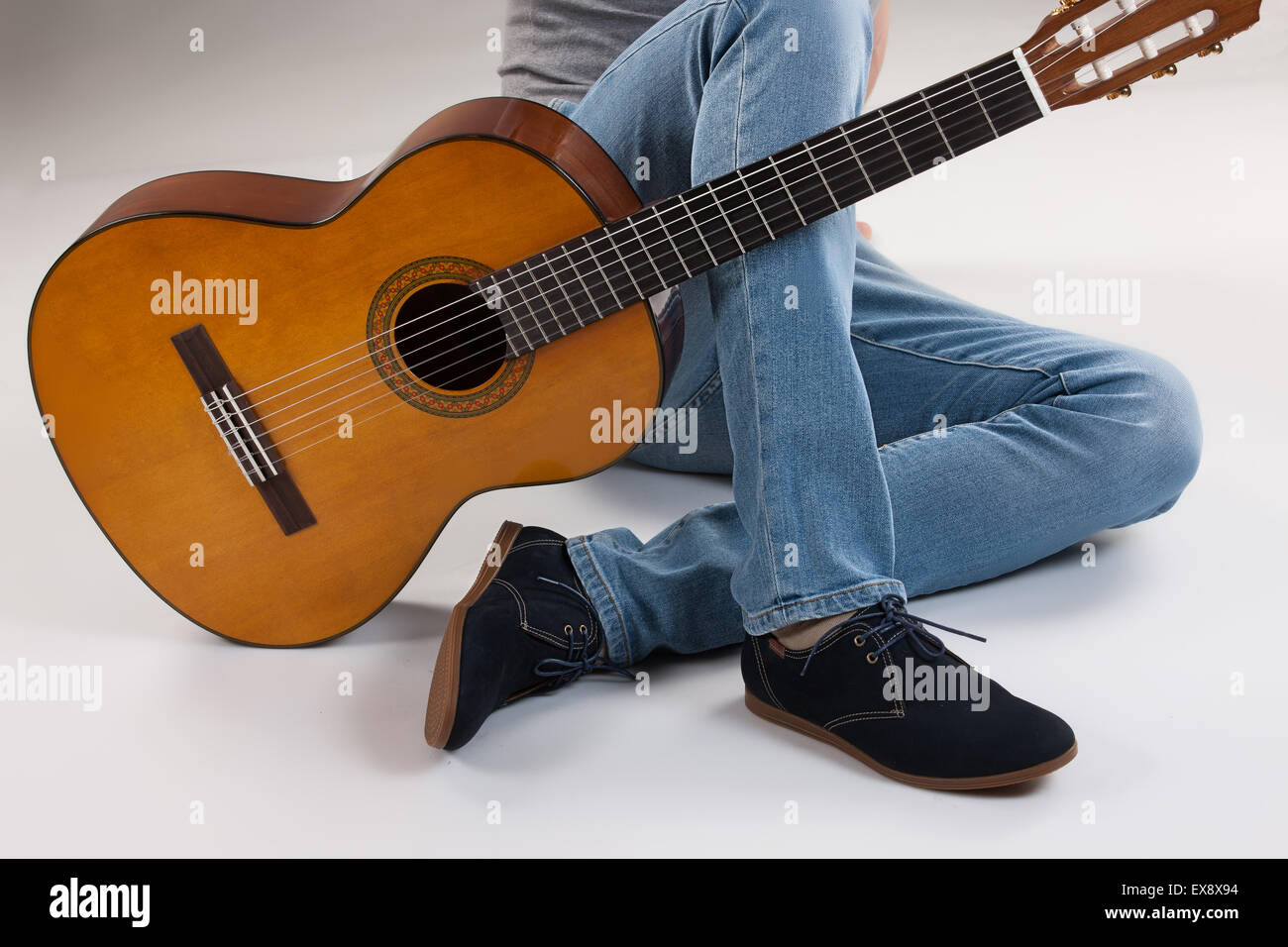 Uomo uomini studio maschio jeans denim di sfondo dell'oggetto suonare la chitarra parte del corpo dello strumento musicale gruppo isolato di stringa scarpe arte collo Foto Stock