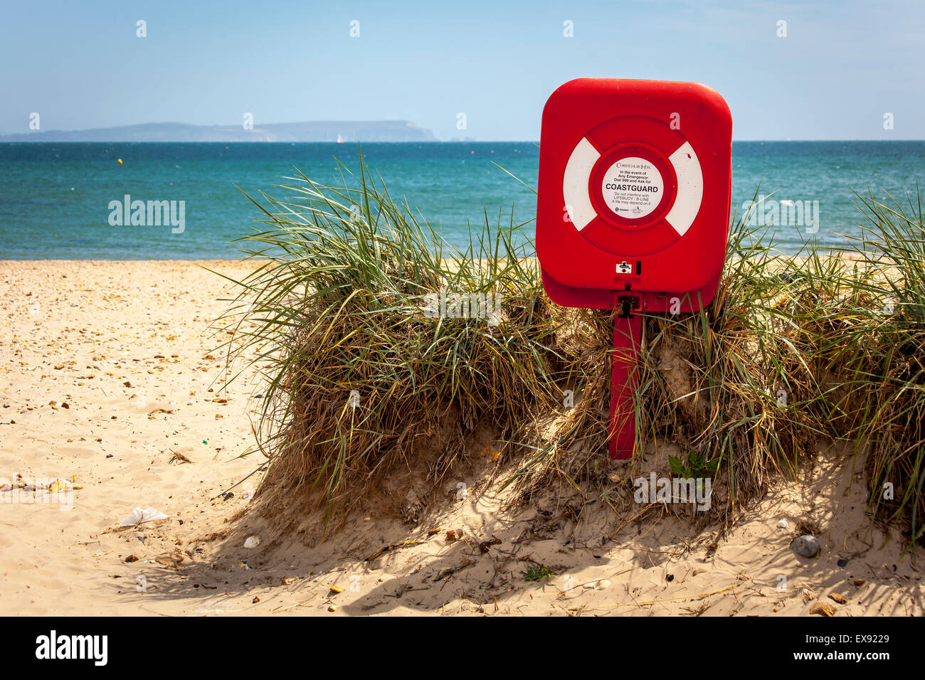 Un rosso post con la vita la boa nel dune di sabbia a testa Hengistbury su la costa del Dorset con l'Isola di Wight a distanza Foto Stock