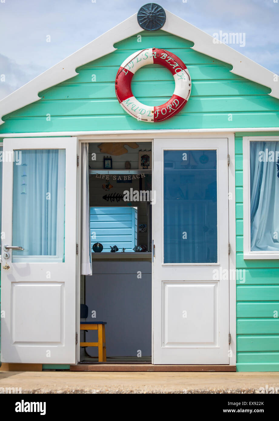 Una porta aperta per un verde beach hut su un giorno d'estate a testa Hengistbury vicino a Christchurch per la costa del Dorset Foto Stock