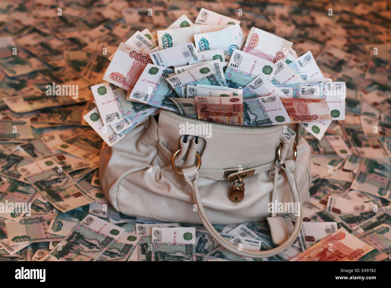 Migliaia di rubli. 1000₽ e 5000₽ note. Una borsa piena di denaro e pavimento coperto di banconote. Foto Stock