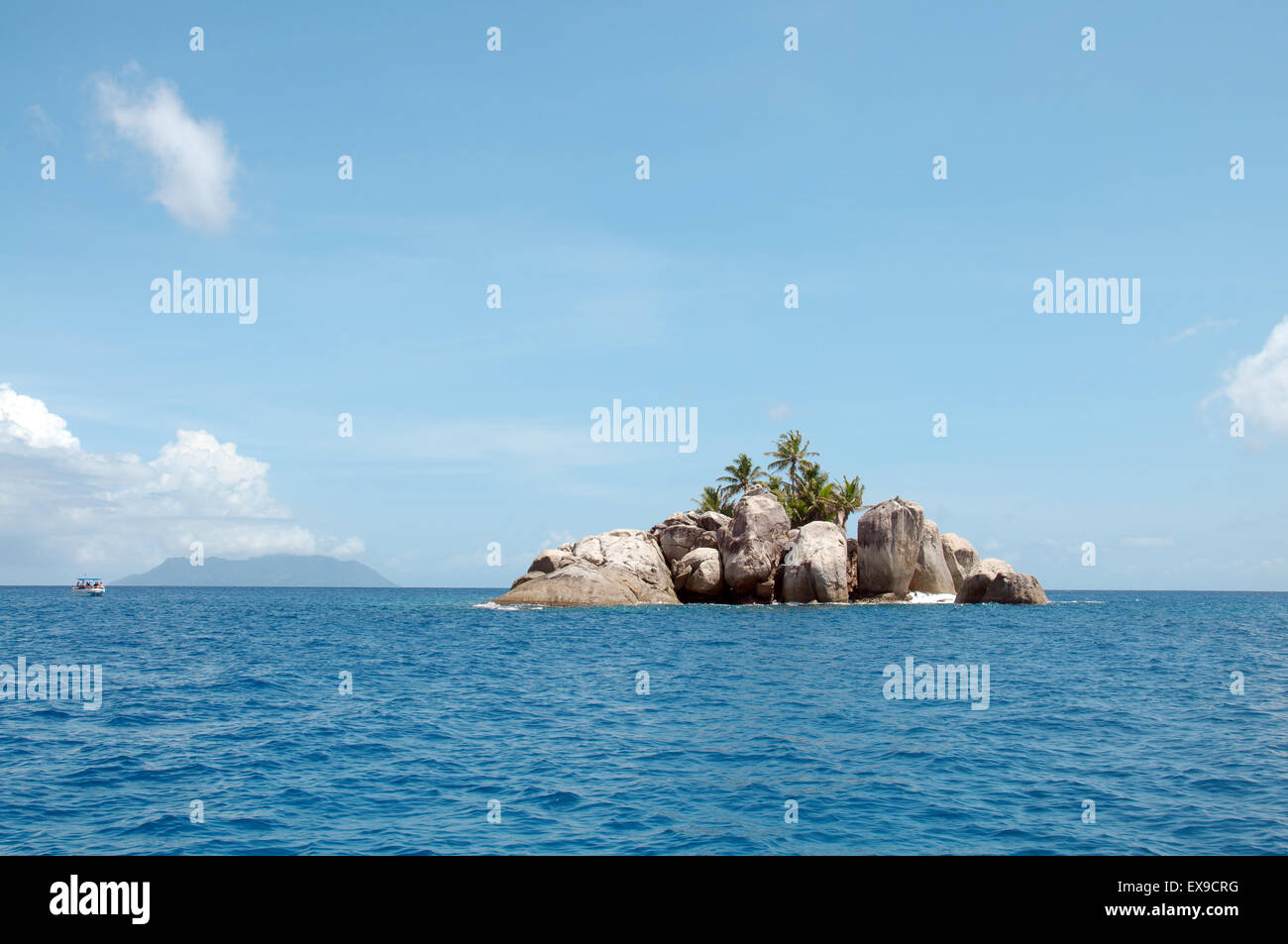 Una piccola isola rocciosa con palme vicino l'isola di Mahe, Oceano Indiano, Seicelle Foto Stock