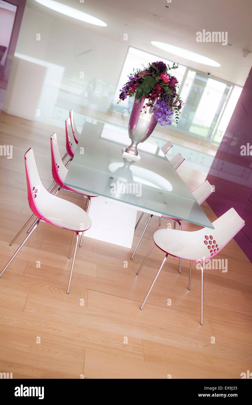 Post-moderno tavolo da pranzo e zona. colori vibranti, ben illuminata, saturo, con display floreale in un vaso di grandi dimensioni come decorazione Foto Stock