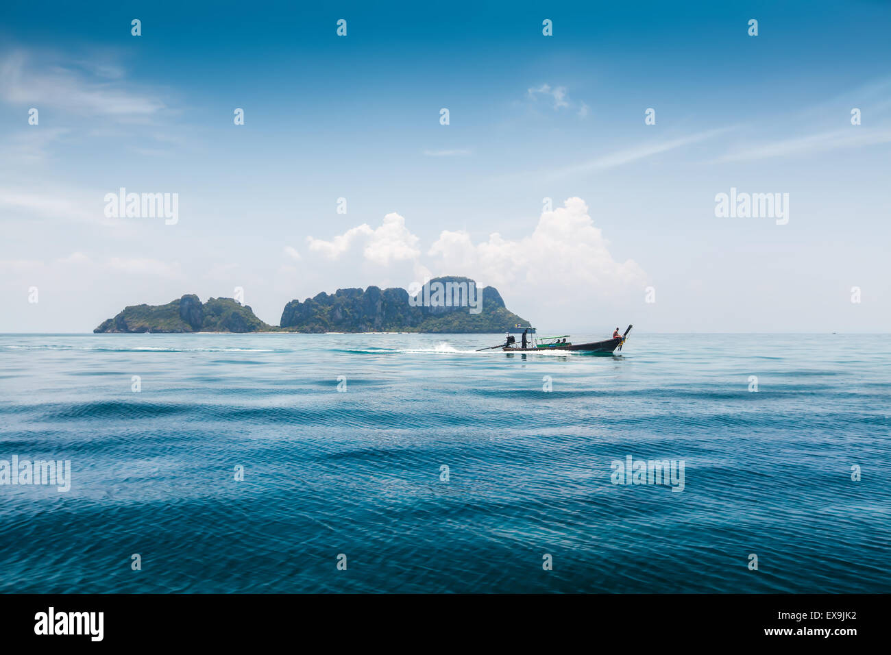 Barca dalla coda lunga con i passeggeri in movimento su blu mare tropicale della Thailandia Foto Stock