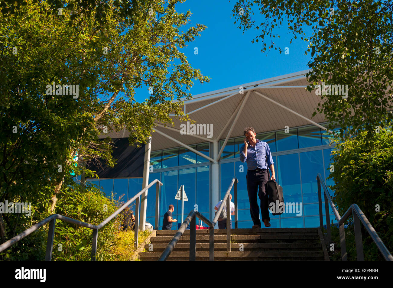 Uomo che parla al telefono cellulare presso l'aeroporto di Bristol, Inghilterra, Regno Unito Foto Stock
