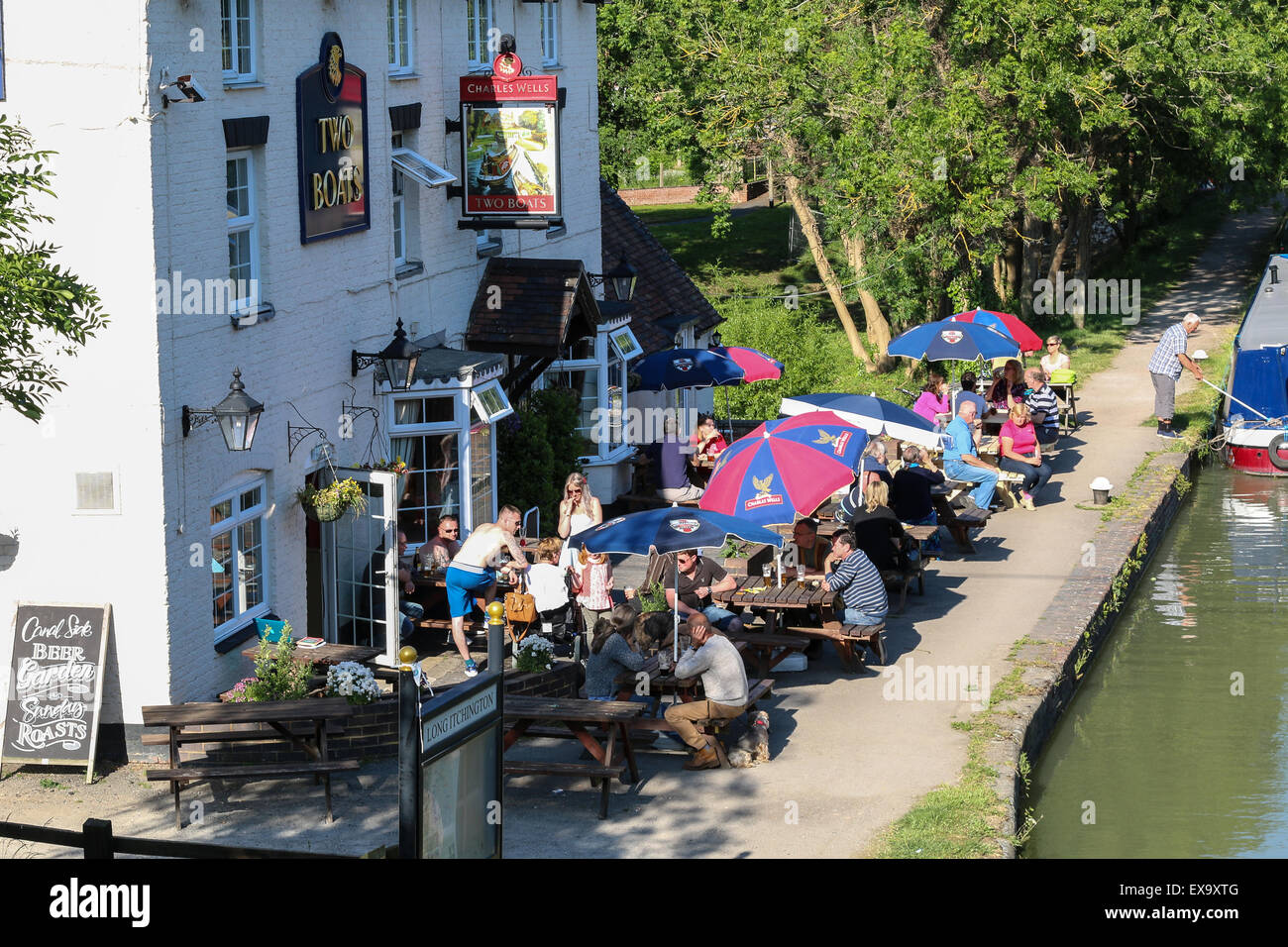 Una banca Canale di Beagle pub di campagna inglese le due imbarcazioni al Long Itchington è un popolare pub per mangiare fuori accanto al canale. Foto Stock