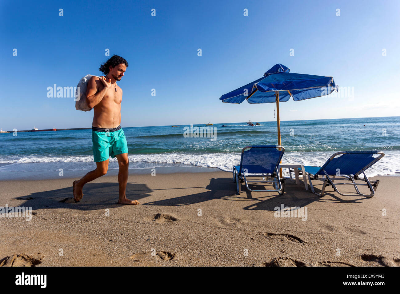 Uomo che cammina da solo su una spiaggia di Rethymno, Creta, Grecia Foto Stock