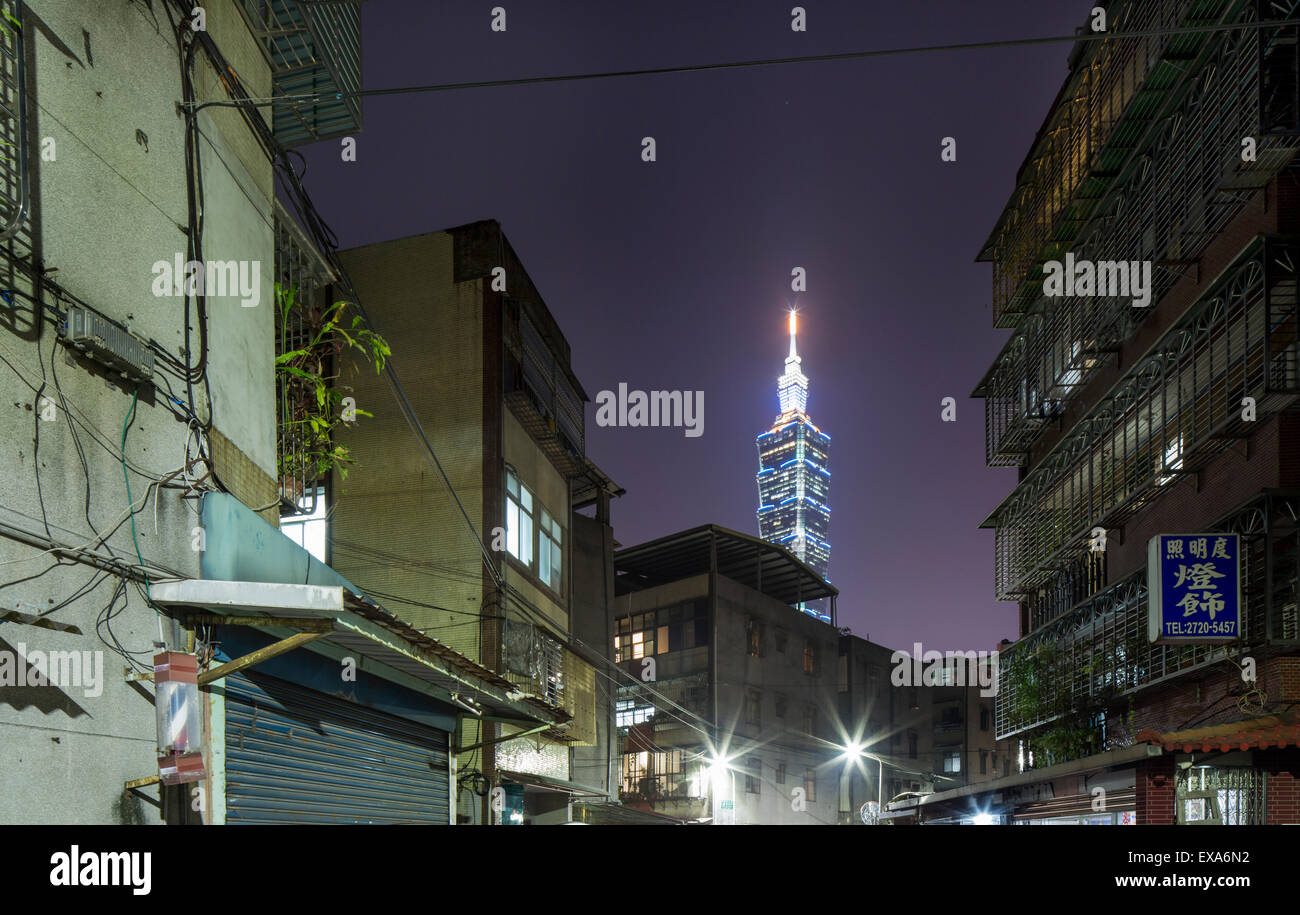 Asia, Taiwan, Taipei grattacielo Taipei 101 sale al di sopra di stretto vicolo in Kennedy Town quartiere di notte sulla sera d'inverno Foto Stock