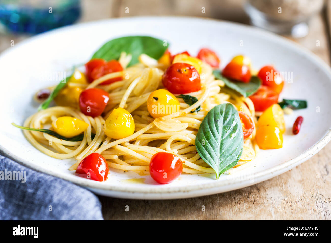 Spaghetti con il giallo e il rosso pomodoro ciliegino dal mare sale e olio di oliva Foto Stock