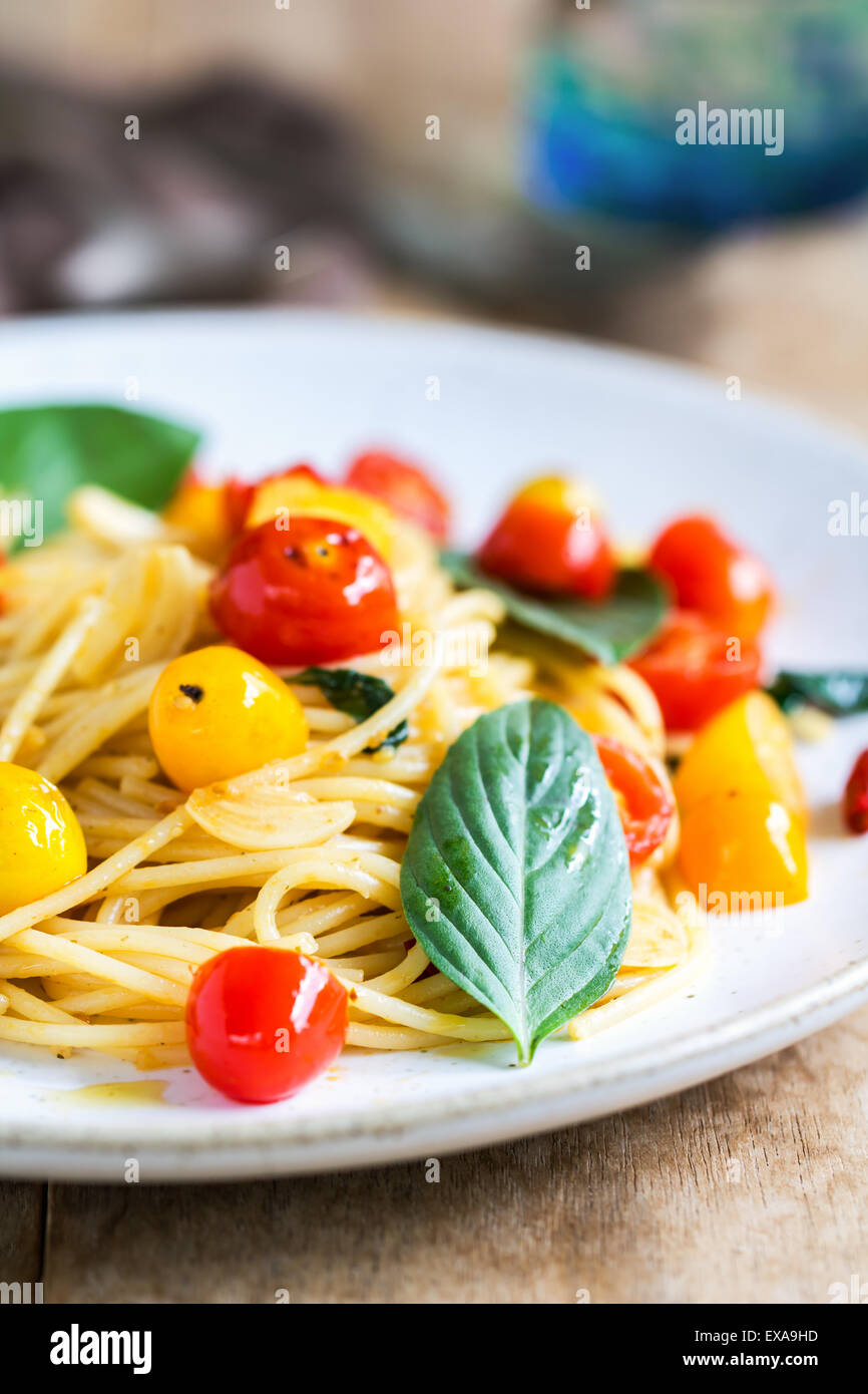 Spaghetti con il giallo e il rosso pomodoro ciliegino dal mare sale e olio di oliva Foto Stock