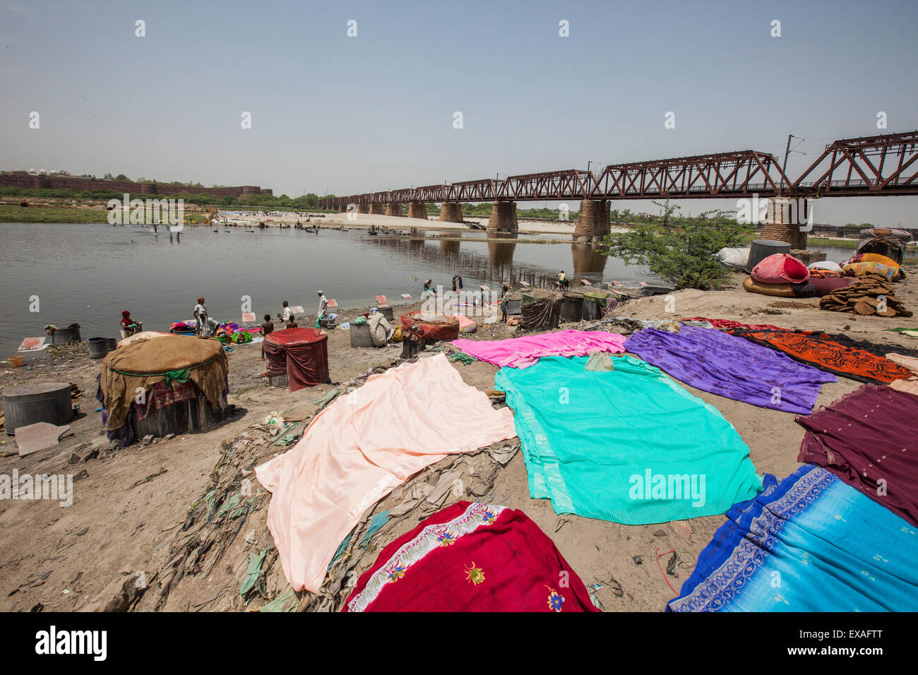 Abiti colorati di essiccazione al sole sulle rive del fiume Yamuna, un affluente inquinati del Gange, Nuova Delhi, India, Asia Foto Stock