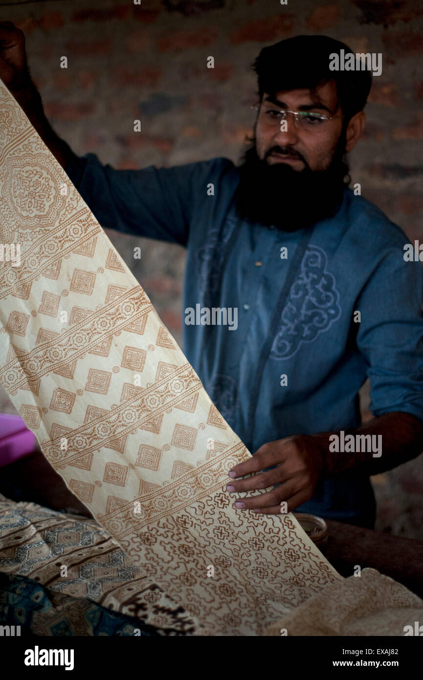 Uomo musulmano che mostra il blocco a mano tessuto stampato utilizzando il colorante naturale costituito da piante e radici, Bhuj district, Gujarat, India, Asia Foto Stock