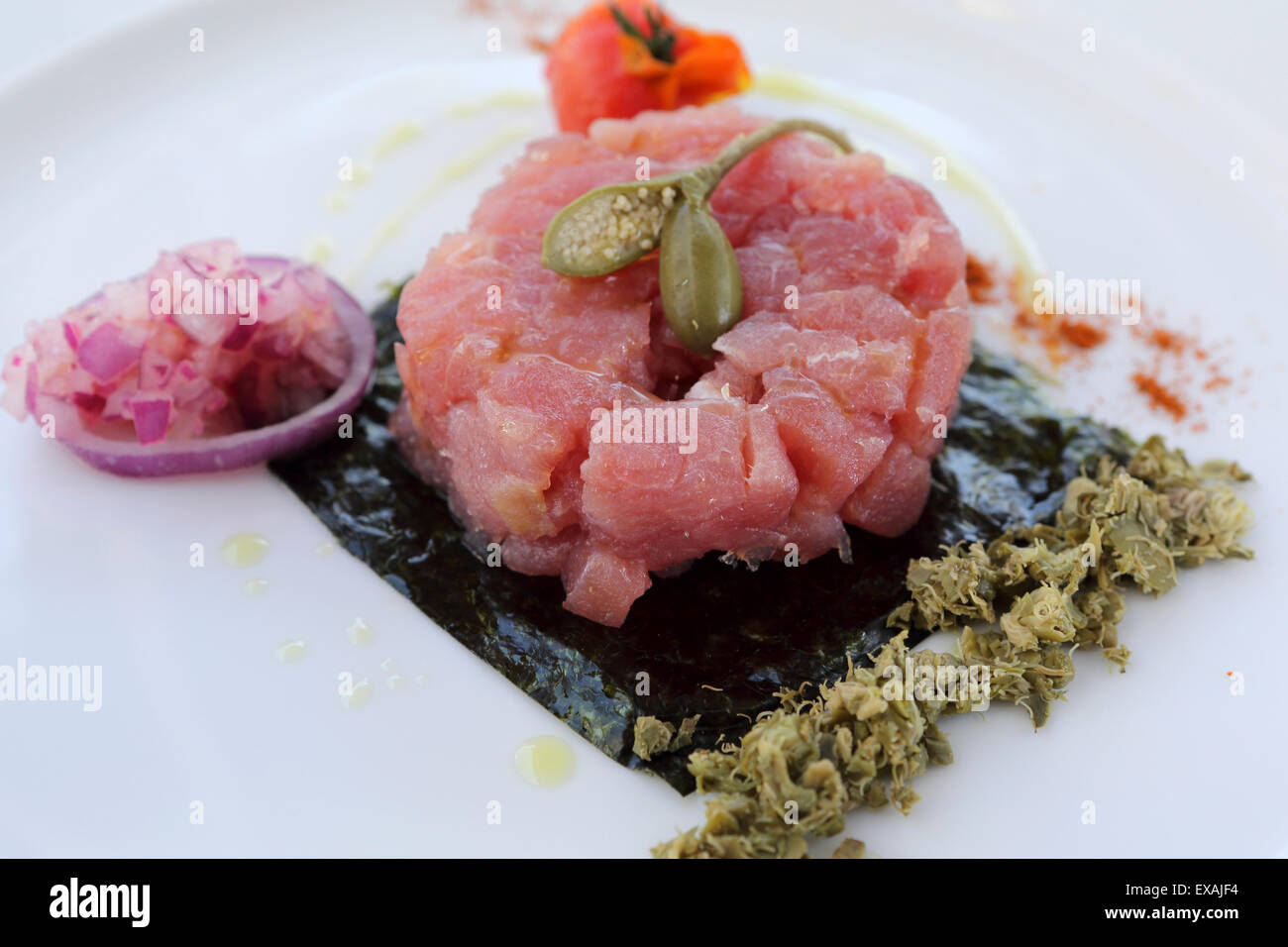 Red tartare di tonno con olio oilive, una figura e la cipolla è servita a Monopoli, Puglia, Italia, Europa Foto Stock