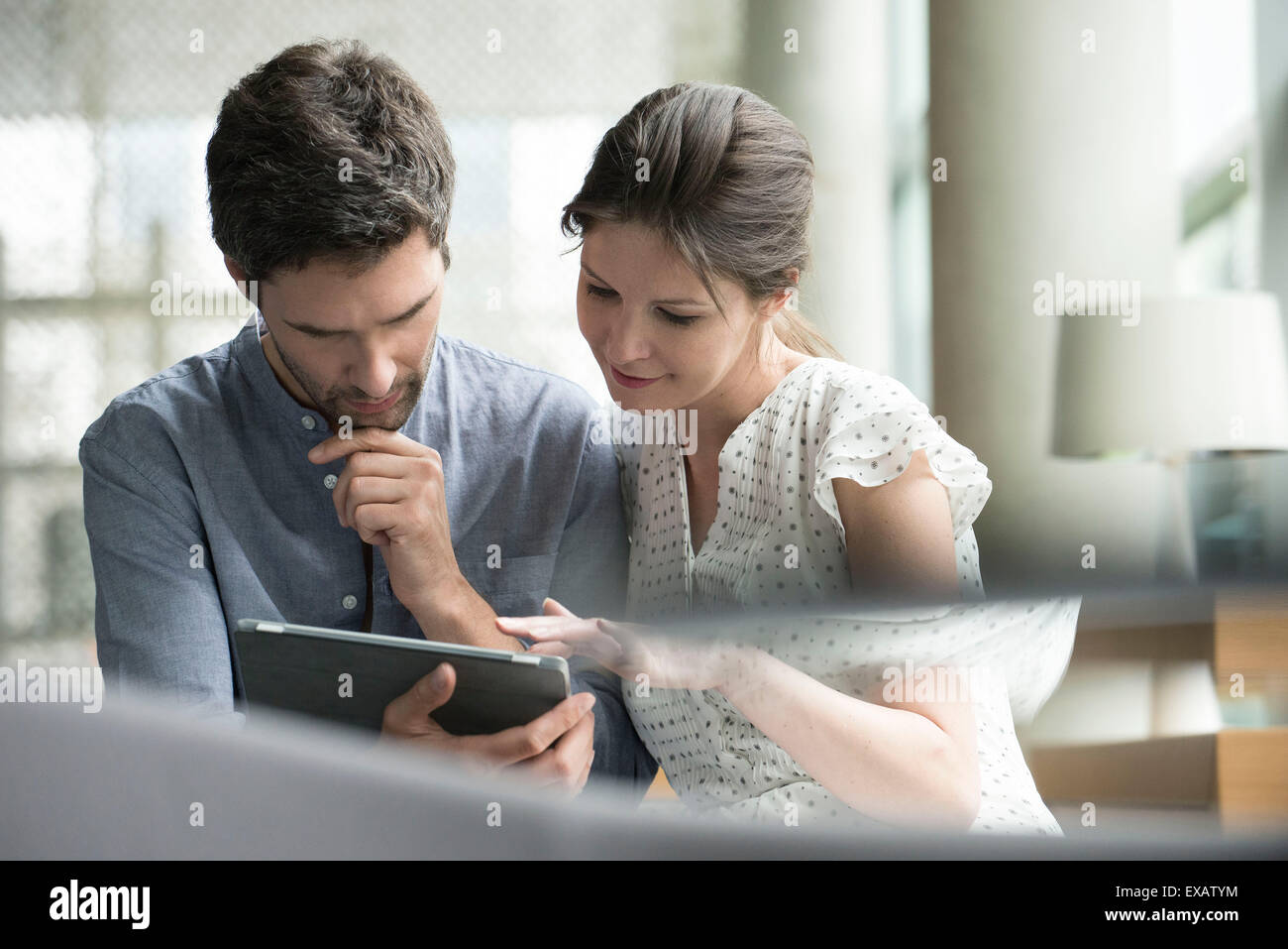 Giovane con tavoletta digitale insieme a casa Foto Stock