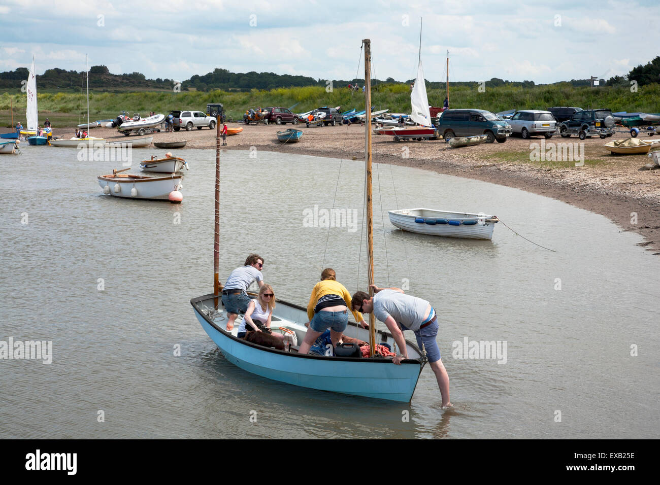 I giovani l'impostazione off nella piccola barca a vela da Morston quay, Norfolk. Foto Stock