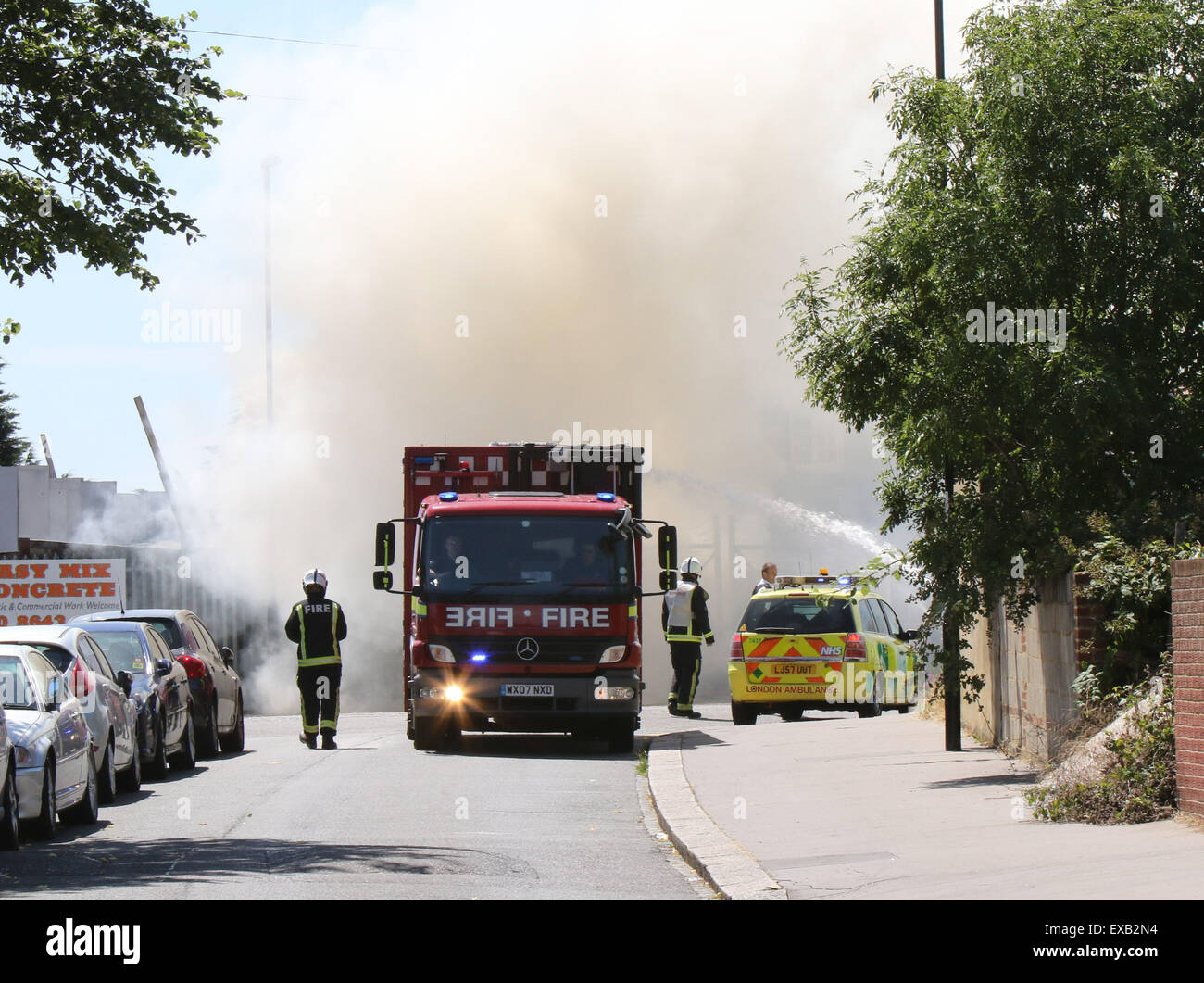 Croydon, Surrey venerdì 10 luglio 2015 Quattro motori Fire e una ventina di vigili del fuoco sono stati chiamati per un incendio al costruttore cantiere sulla corsia di fabbrica a Croydon questo pomeriggio il fuoco ha riguardato circa due tonnellate di rifiuti sfusi e una bombola di butano che equipaggi raffreddato. Station Manager Sally Harper che era presso la scena ha detto: "Il fuoco è stata ben sviluppata quando siamo arrivati e i nostri equipaggi hanno lavorato duramente per ottenere rapidamente sotto controllo. Grazie ai loro sforzi, il fuoco era limitata alla fase di cantiere, sebbene noi evacuata una casa nelle vicinanze proprio come una precauzione. Credito: Jason Kay/Alamy Live News Foto Stock