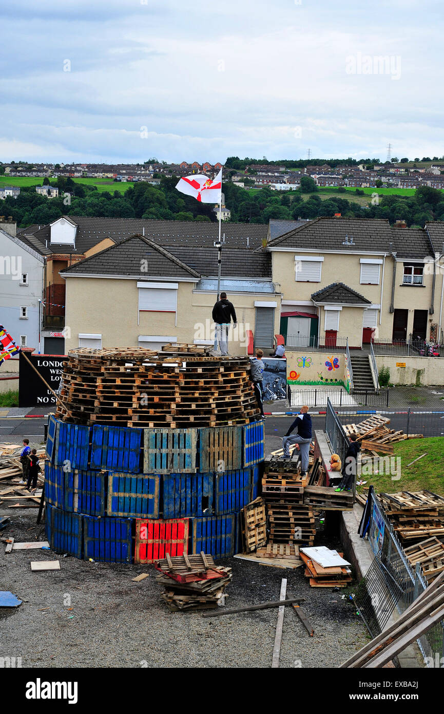 Londonderry, Irlanda del Nord, Regno Unito. 10 Luglio, 2015. Falò costruito davanti a annuale ordine arancione parate, Londonderry, Irlanda del Nord - 10 luglio 2015. Lealisti nella fontana Estate costruire una undicesima notte falò, con pallet e pneumatici, per essere acceso prima dell'annuale "dodicesimo" di luglio ordine arancione parate. Il XII Luglio commemora il nel 1690 quando il re protestante Guglielmo III sconfitto il esiliato re cattolico Giacomo II. © George Sweeney/Alamy Live News Credito: George Sweeney/Alamy Live News Foto Stock