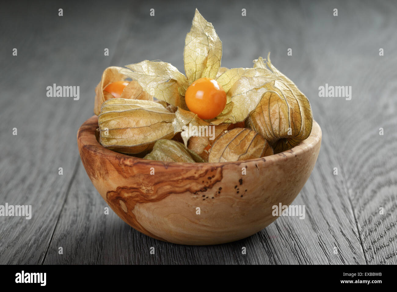 Physalis frutto nella tazza di olive su oak tavolo in legno Foto Stock