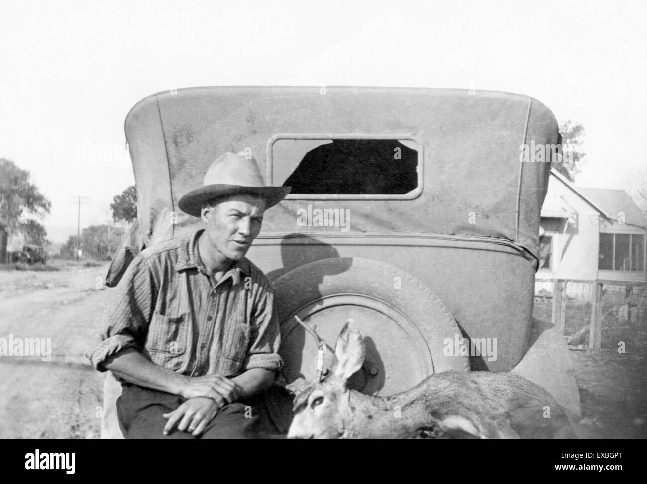 Un nuovo cacciatore del Messico nel 1929 con un mulo cervo legato sul retro della sua automobile Foto Stock