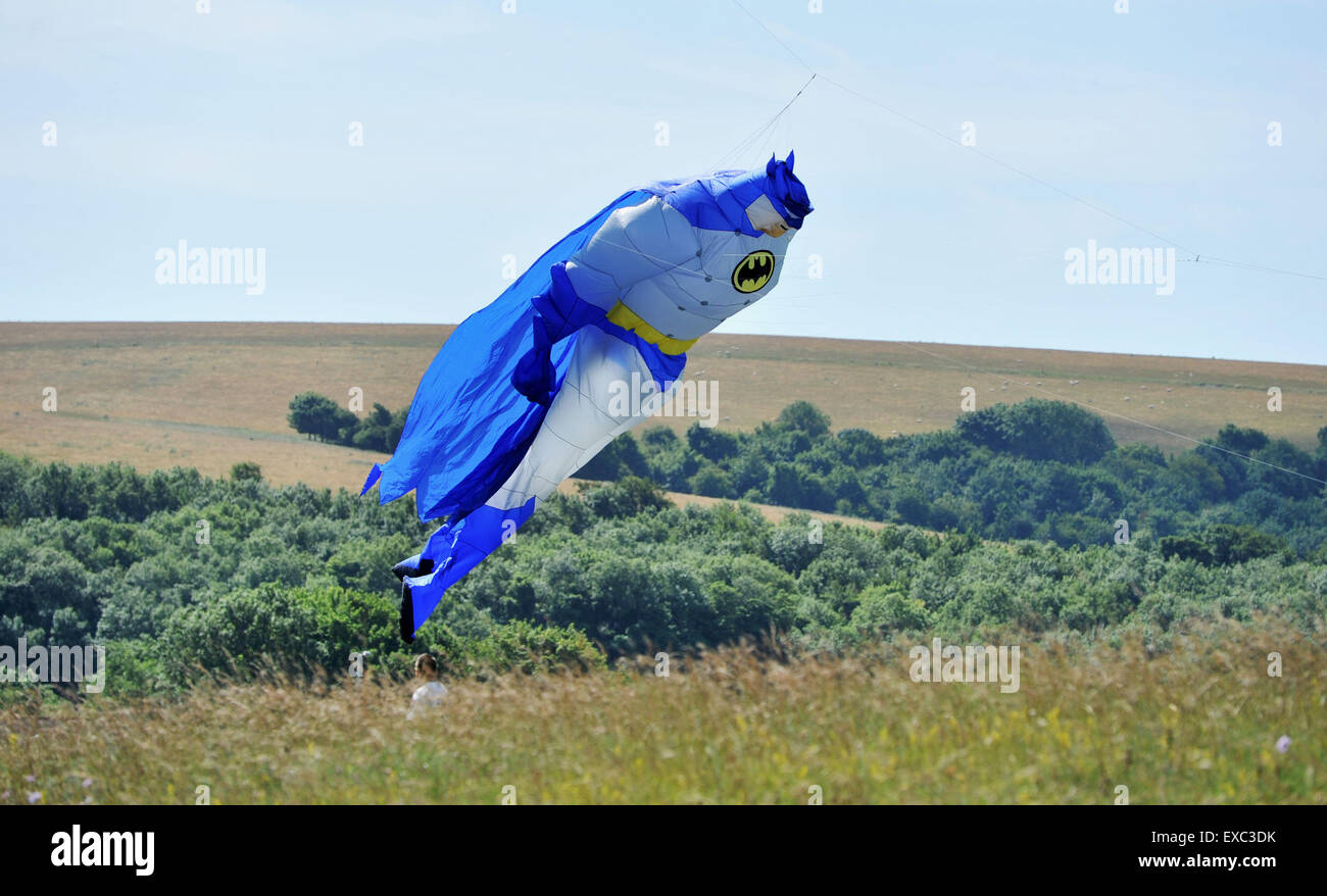 Brighton, Regno Unito. 11 Luglio, 2015. Perfetto battenti meteo con sole caldo e una brezza come un gigante di Batman aquilone vola sopra il Downs questa mattina il primo giorno dell'annuale Brighton Kite Festival che si svolge nel Parco Stanmer questo weekend Credito: Simon Dack/Alamy Live News Foto Stock