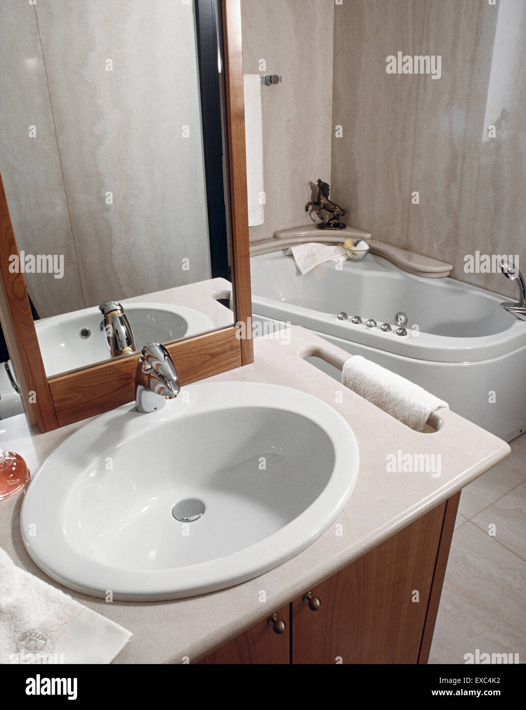 In primo piano del lavandino che si affaccia sulla vasca nel bagno moderno la cui parete e pavimento sono rivestiti in marmo Foto Stock