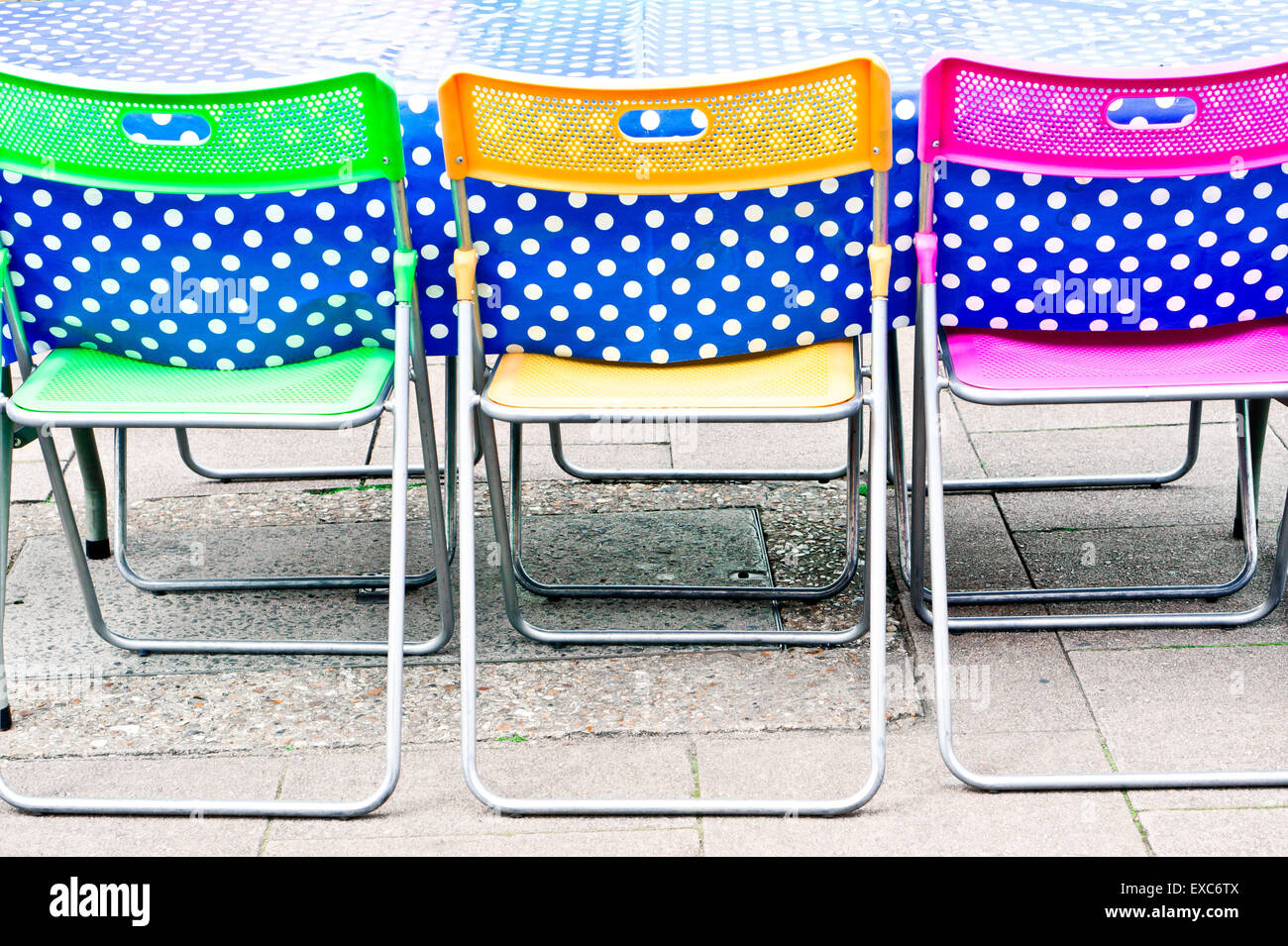 Colorate sedie a un tavolo da picnic Foto Stock