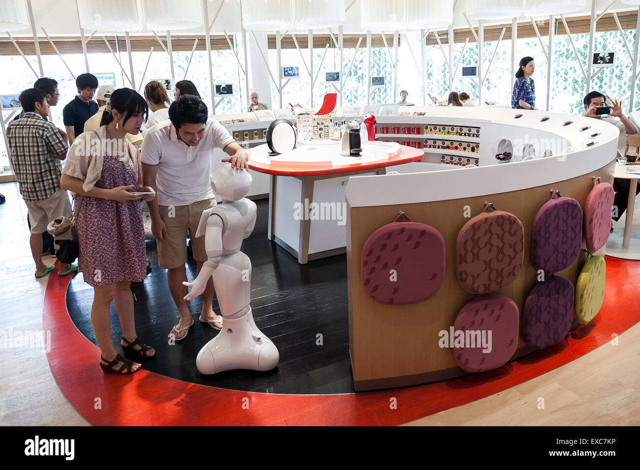 Tokyo, Giappone. 11 Luglio, 2015. I clienti a salutare il robot umanoide Pepe sul suo primo giorno come un nuovo membro del personale del Nescafe coffee-shop in Harajuku sulla luglio 11, 2015, Tokyo, Giappone. Sei i robot sono programmati per interagire con le persone mentre introducendo il Nescafe prodotti durante un evento speciale ''Il mondo? Futuro cafe da NESCAFE con pepe'" sabato 11 luglio. Il negozio continuerà a impiegare due robot come regular staff per introdurre il negozio di prodotti e servizi. Credito: Rodrigo Reyes Marin/AFLO/Alamy Live News Foto Stock