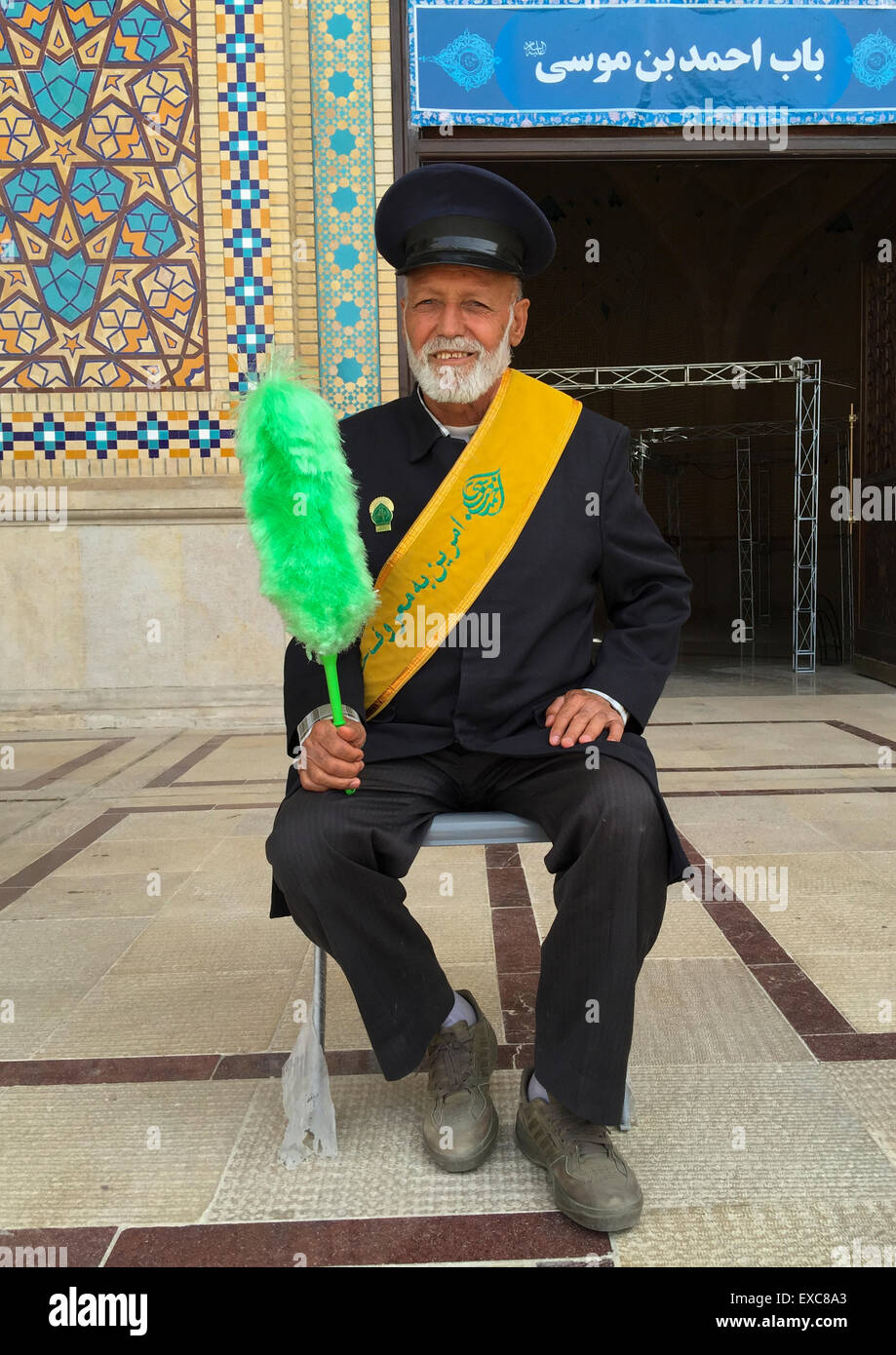 La protezione con una verde Feather Duster a Shah-e-cheragh Mausoleo, far Provincia, Shiraz, Iran Foto Stock