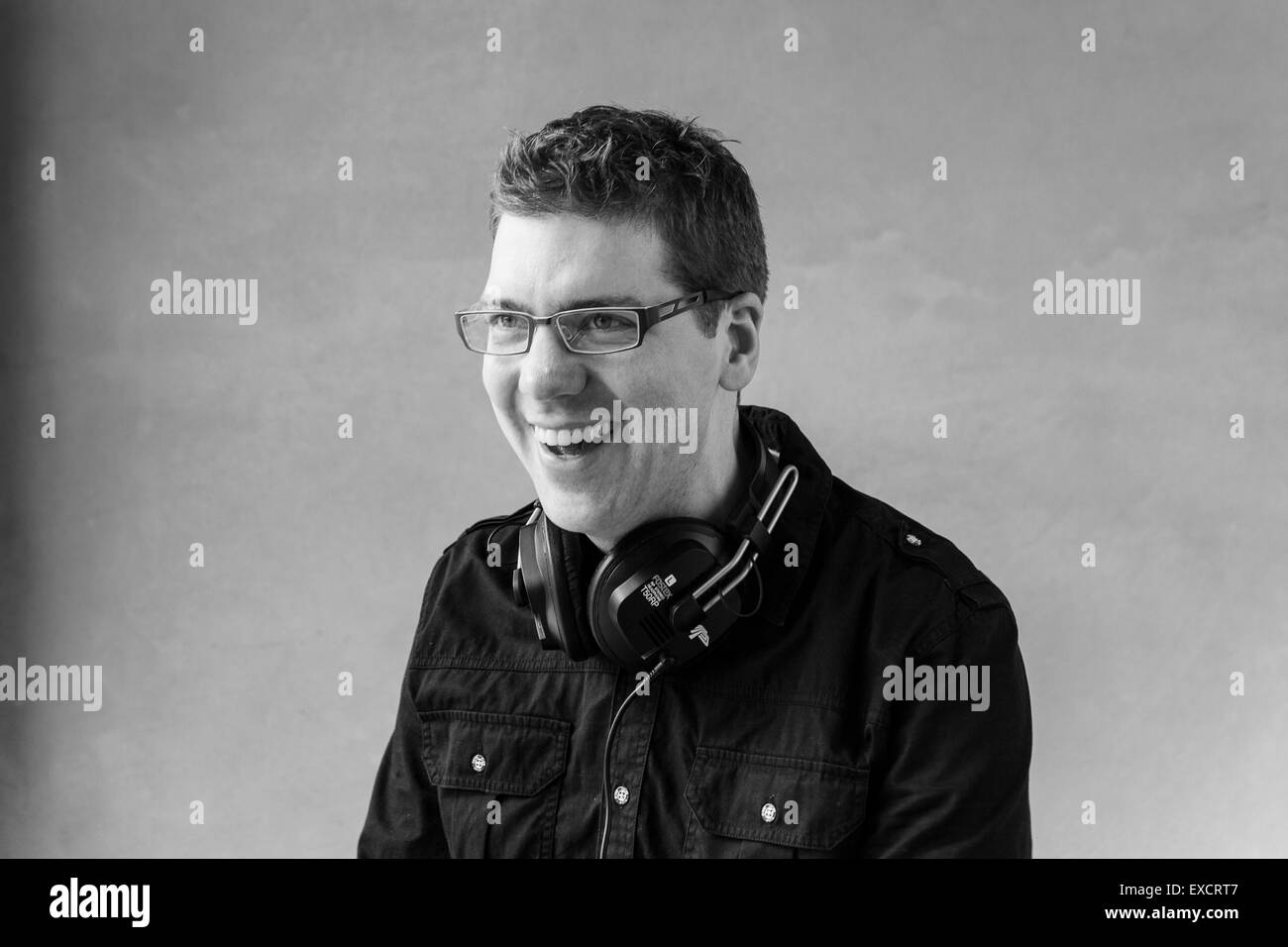 Un bianco e nero ritratto in studio di un elegante hipster DJ che indossa le sue cuffie Foto Stock