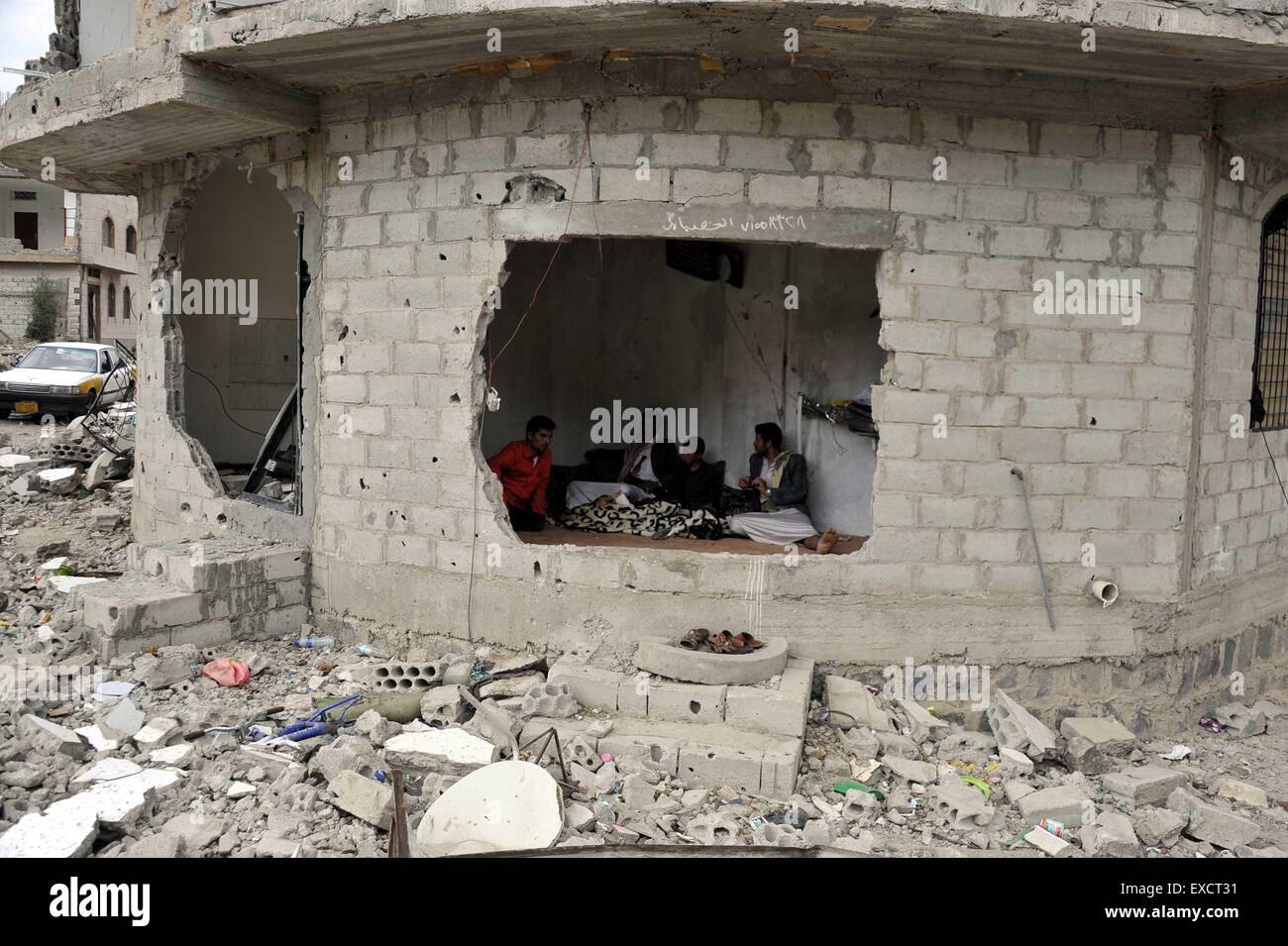 Sanaa, Yemen. 11 Luglio, 2015. Yemenis sono visibili nella loro casa che era stato distrutto in aerei in Sanaa, Yemen, sulla luglio 11, 2015. Il cessate il fuoco che era stato annunciato dalle Nazioni Unite ha iniziato il 23:59 (2059 GMT) di venerdì e durerà fino alla fine dei musulmani sacro mese del Ramadan il 17 luglio. Tuttavia, la lotta infuria in Yemen dopo un Nazioni Unite-mediate tregua umanitaria è entrato in vigore fin da sabato come le parti in conflitto sono stati accusati di aver violato il cessate il fuoco, funzionari e testimoni ha detto. Credito: Hani Ali/Xinhua/Alamy Live News Foto Stock