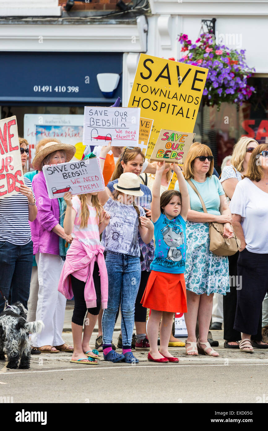 Henley-on-Thames, Regno Unito. 11 Luglio, 2015. Le giovani ragazze in una folla di dimostranti tenere fatti in casa a base di cartelli in un pacifico corteo di protesta per il 'Salva i nostri letti' campagna a Henley-on-Thames, Oxfordshire, Inghilterra, sabato 11 luglio 2015, protestando contro la clinica Oxfordshire messa in esercizio del gruppo i piani per il nuovo campus della salute, Townlands ospedale. Il nuovo ospedale era stato originariamente programmato per avere 18 letti, ora cambiata a 5 letti in una casa di cura per essere costruito accanto all'ospedale, che lascerebbe Townlands senza letti per 6 mesi. Credito: Graham Prentice/Alamy Live News Foto Stock