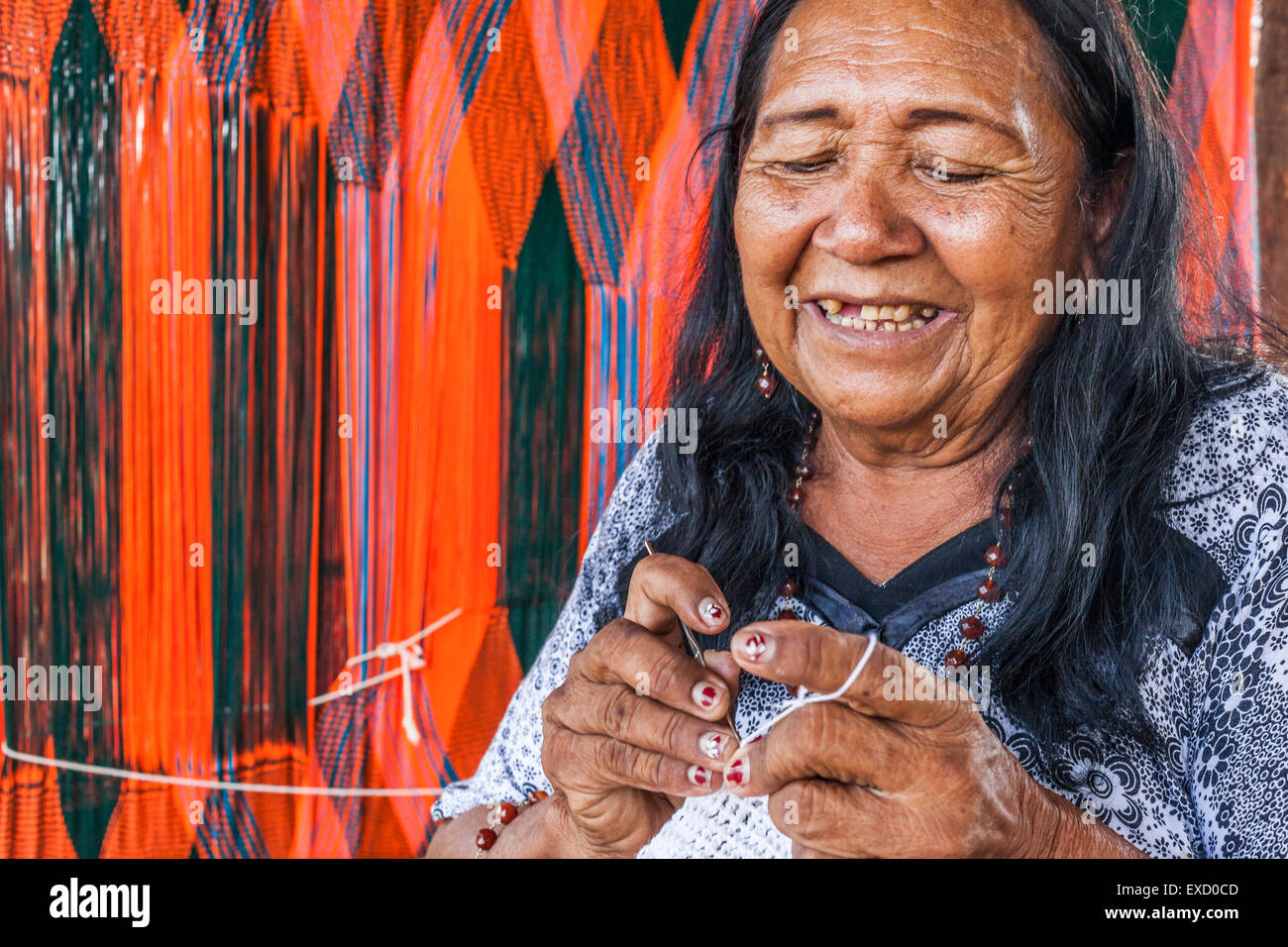 Anziani Wayuu donna indigena la tessitura di una 'chinchorro' o amaca colombiana. Lavorazione a maglia, a crochet e tessitura sono fondamentali per Foto Stock