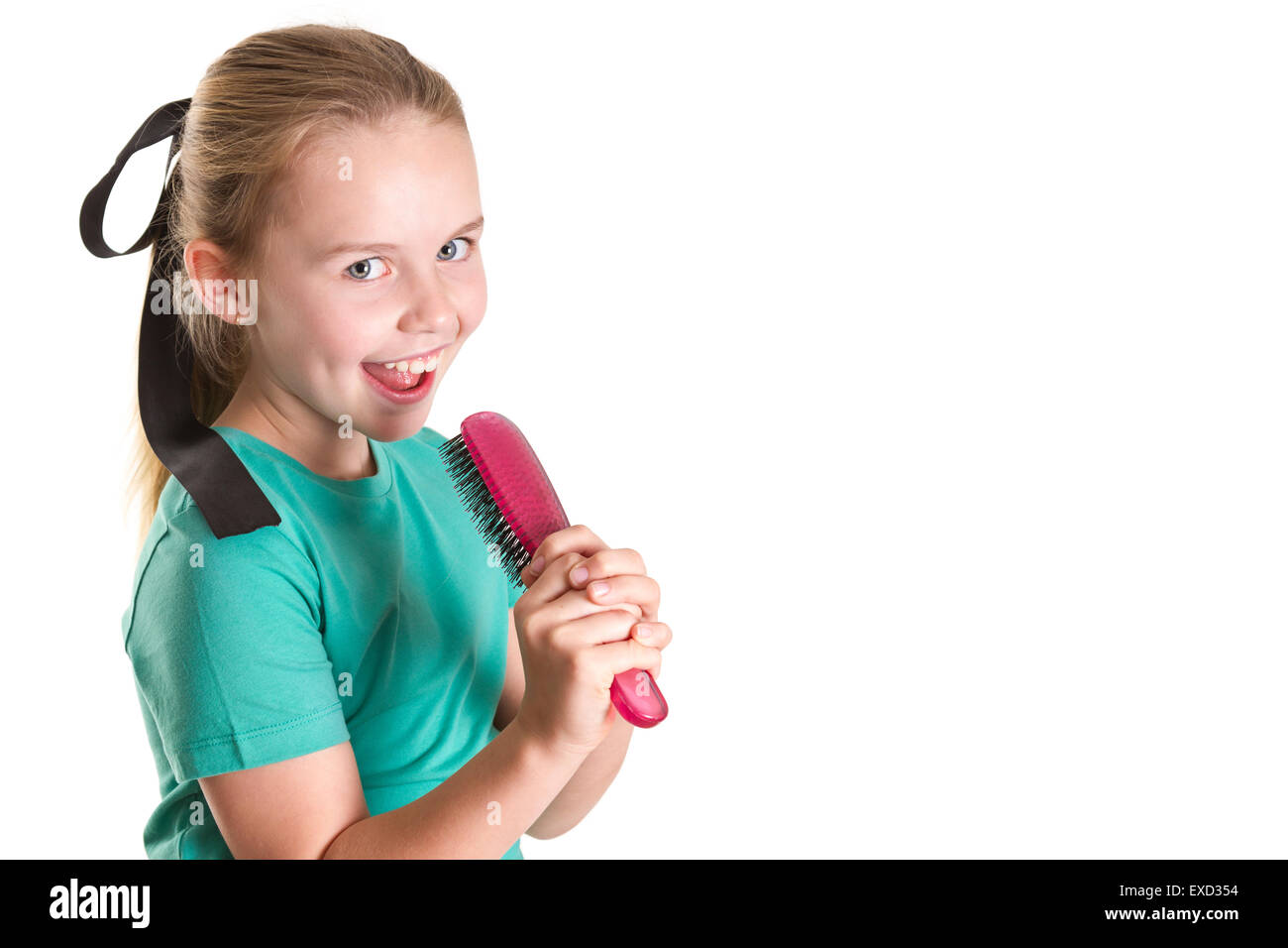 Ragazza giovane dichiara che la sua spazzola per capelli è un micro-telefono e canto. Foto Stock