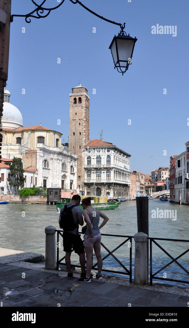 Italia Venezia Canale Grande Santa Croce regione - coppia giovane - libro guida controllare - opposta a San Geremia sun+ blu cielo Foto Stock