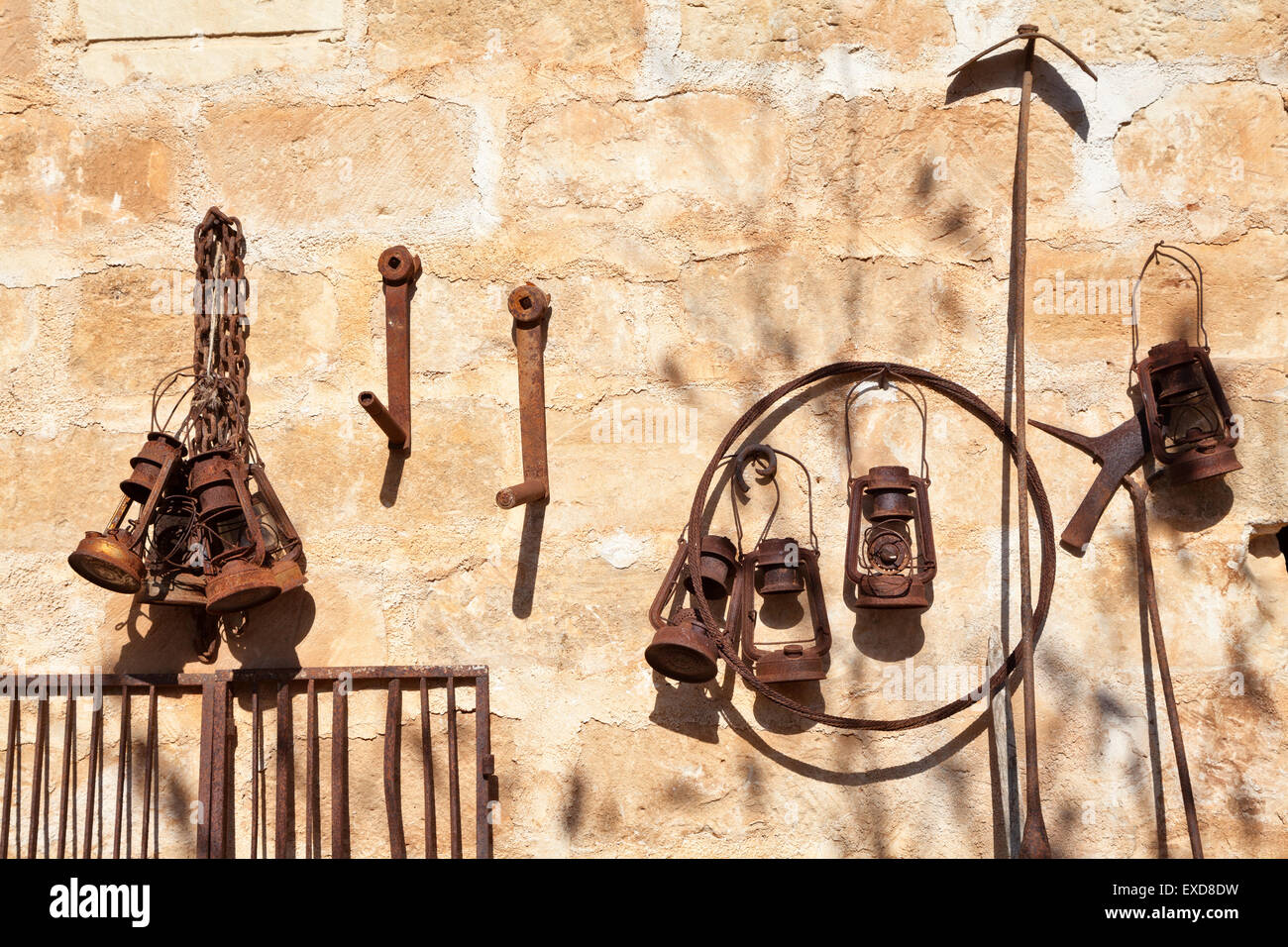 Rusty lanterne appoggiato contro una parete in una fattoria siciliana Foto Stock