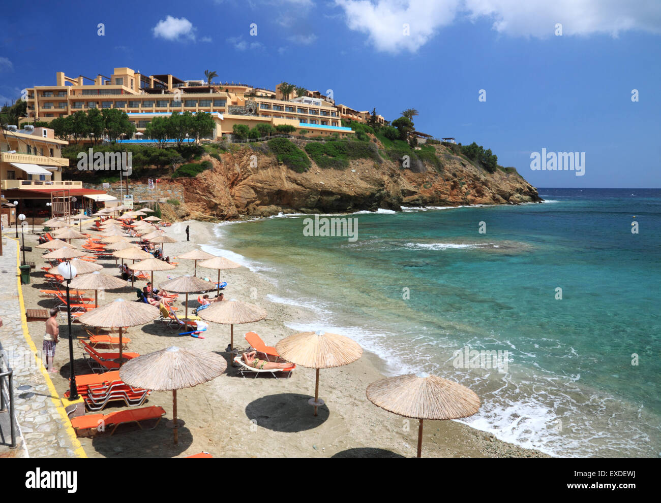 Un moderno resort hotel che si affaccia su una spiaggia mediterranea con ombrelloni e mare turchese. Foto Stock