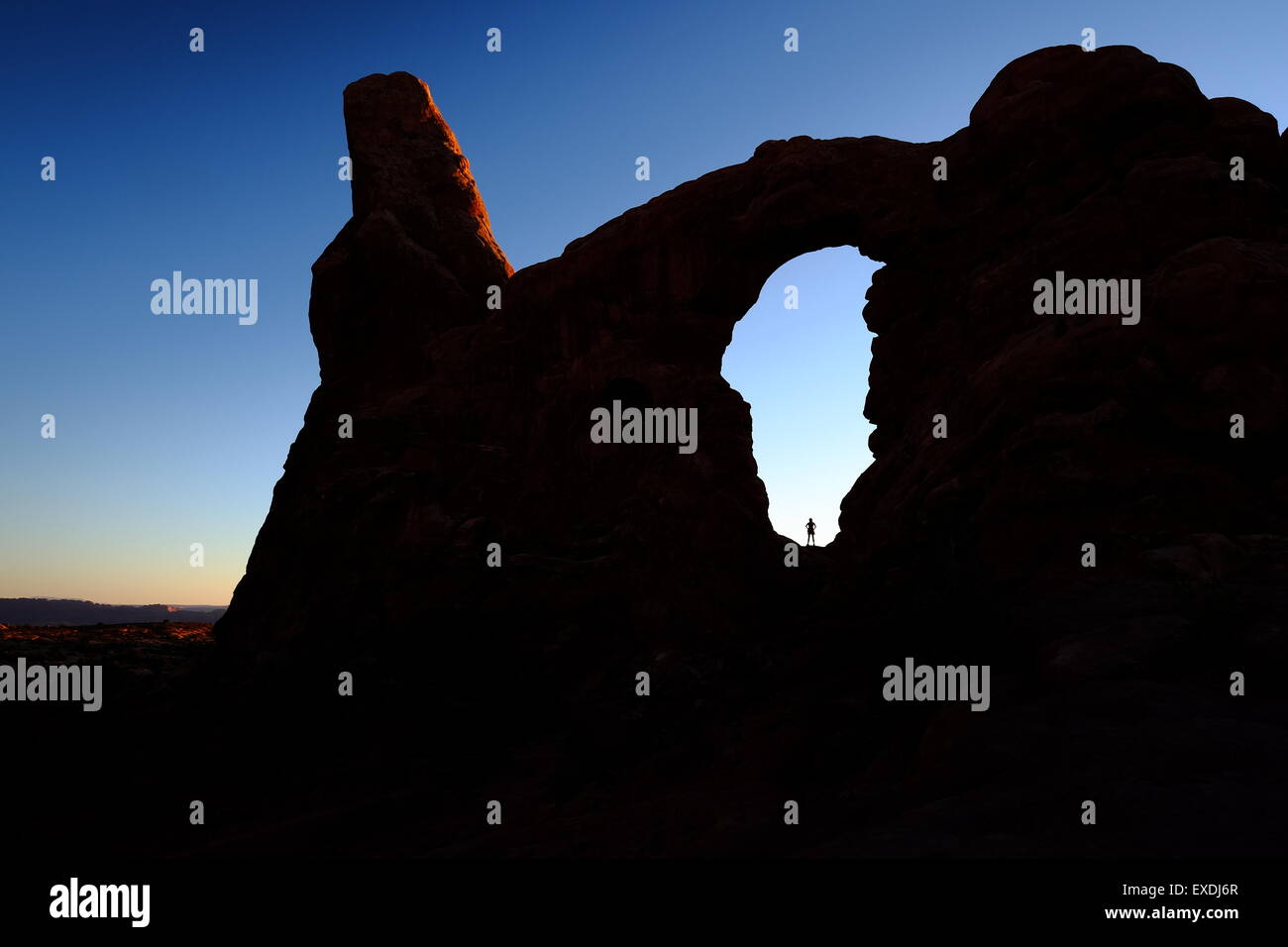 Silhouette di un escursionista in piedi la torretta finestra ad arco, Arches National Park, Utah, Stati Uniti d'America Foto Stock
