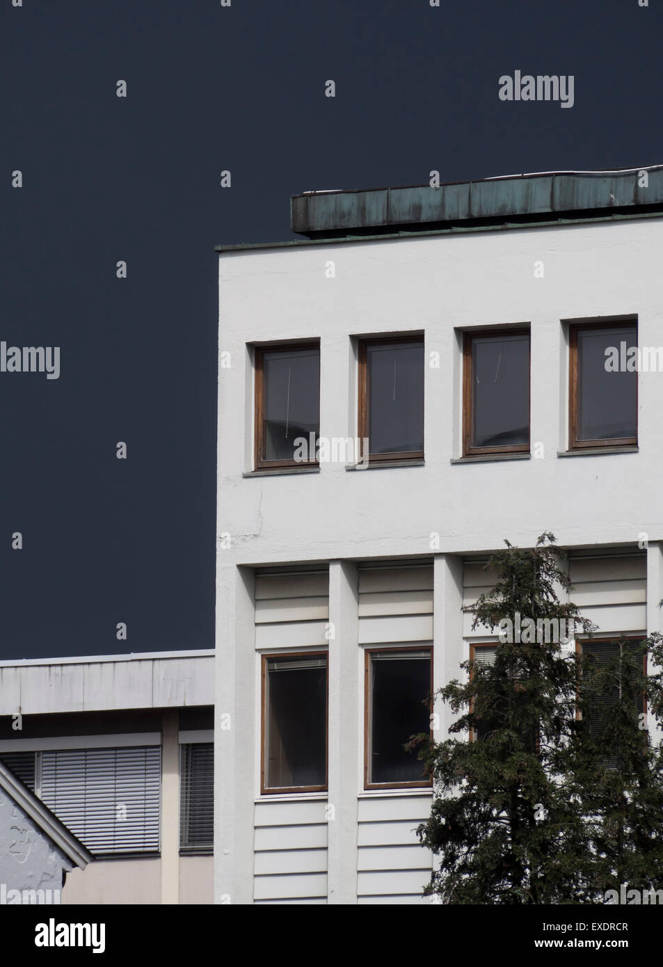 Nuvole temporalesche raccolta dietro edificio commerciale o industriale Foto Stock