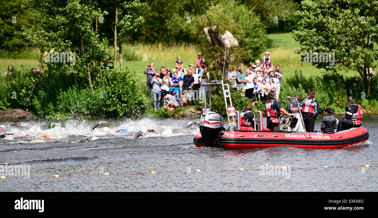 Markeaton Park, Derby, Regno Unito. Il 12 luglio 2015. Pulsante Jensen fiducia Triathlon in aiuto della ricerca sul cancro. I nuotatori Elite ottenere chiudere il coperchio dalla barca di salvataggio come spettatori godersi lo spettacolo. Markeaton Park, Derby, Regno Unito. 12 luglio 2015 Credit: Steve Tucker/Alamy Live News Foto Stock