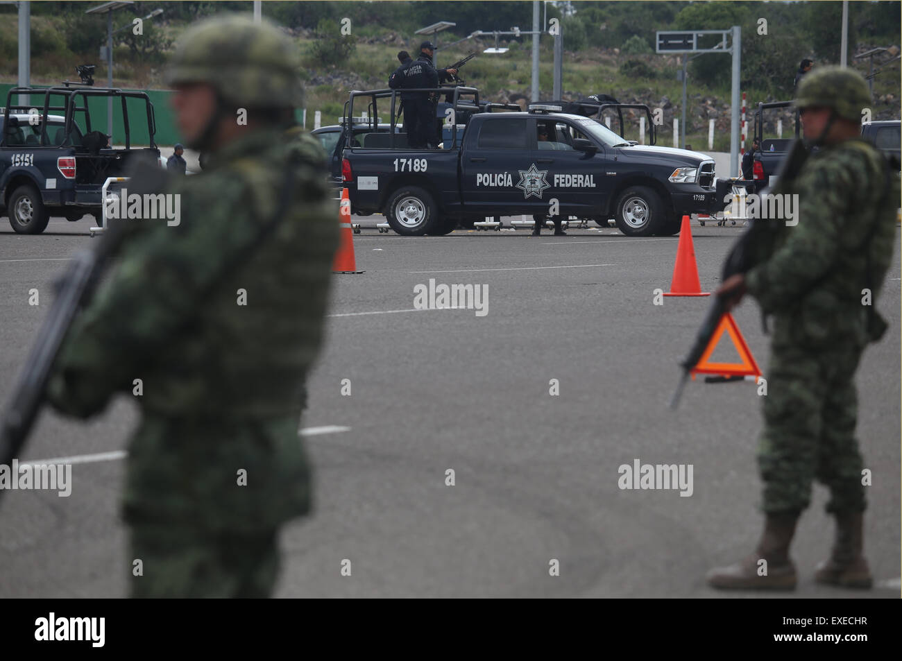 Michoacan, Messico. 12 Luglio, 2015. I membri dell'Ufficio federale di polizia e l'esercito messicano guard nei dintorni del casello di riscossione del pedaggio Contepec dell'autostrada ovest nel Michoacan, Messico, il 12 luglio 2015. Il Messico di farmaco il perno del fuso a snodo del cartello Joaquin 'El' Chapo Guzman fuggiti dal carcere attraverso un 1,5-km tunnel sotto la sua cella, hanno detto le autorità Domenica. Guzman, leader di Sinaloa drug cartello, scomparso dalla massima sicurezza prigione Altiplano al di fuori della Città del Messico Sabato notte, secondo la commissione per la sicurezza nazionale. Credito: Armando Solis/Xinhua/Alamy Live News Foto Stock