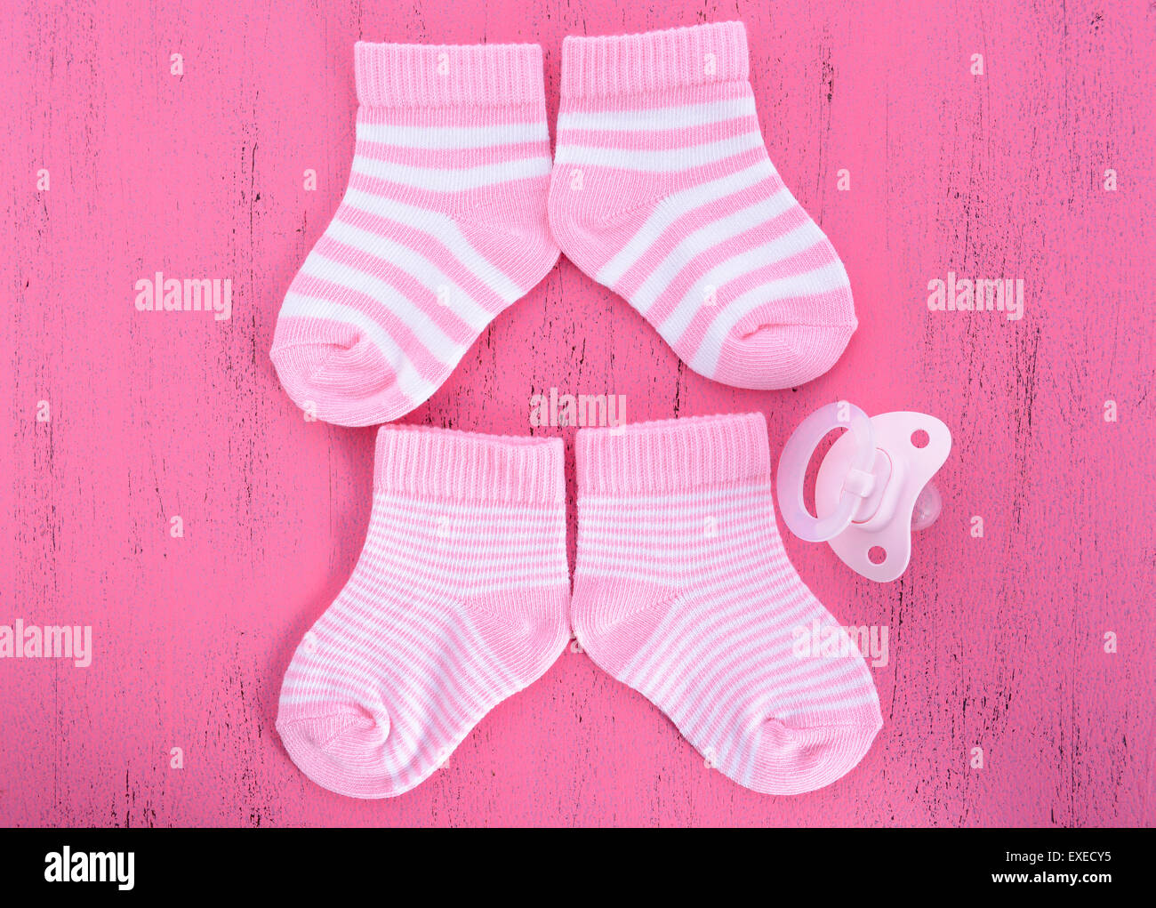 La sua una ragazza Baby doccia o il concetto di vivaio con calzini e succhiotto ciuccio in rosa shabby chic di legno Foto Stock
